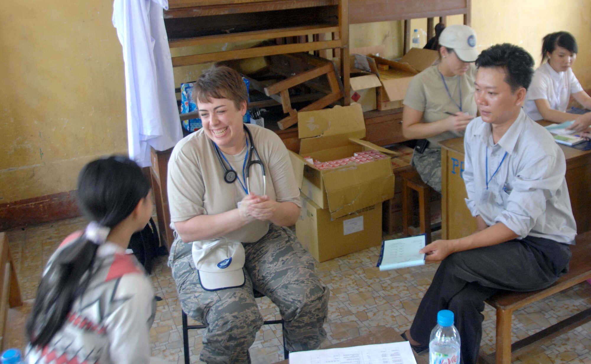 Lt. Col. Laura Peterson and Vietnamese Dr. Tri Duc Nguyen visit with a patient May 10, 2010, in the temporary medical clinic at Tan Thoi, Vietnam, as part of Pacific Angel 10-2. Colonel Peterson is from the Air Force Reserve Command's 477th Aerospace Medicine Flight at Elmendorf Air Force Base, Alaska. (U.S. Air Force photo/Capt. Timothy Lundberg)
