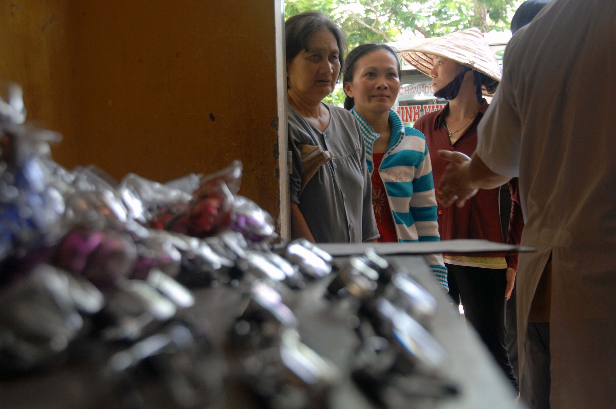 As part of Operation Pacific Angel, scores of Vietnamese villagers wait to be seen by an optometrist in hopes of correcting their vision and receiving a set of prescription glasses stacked on the table  May 10, 2010, in Tan Thoi, Vietnam. Pacific Angel is a joint and combined humanitarian and civic assistance operation conducted in the Pacific in support of U.S. Pacific Command's capacity building efforts. (U.S. Air Force photo/Capt. Timothy Lundberg) 