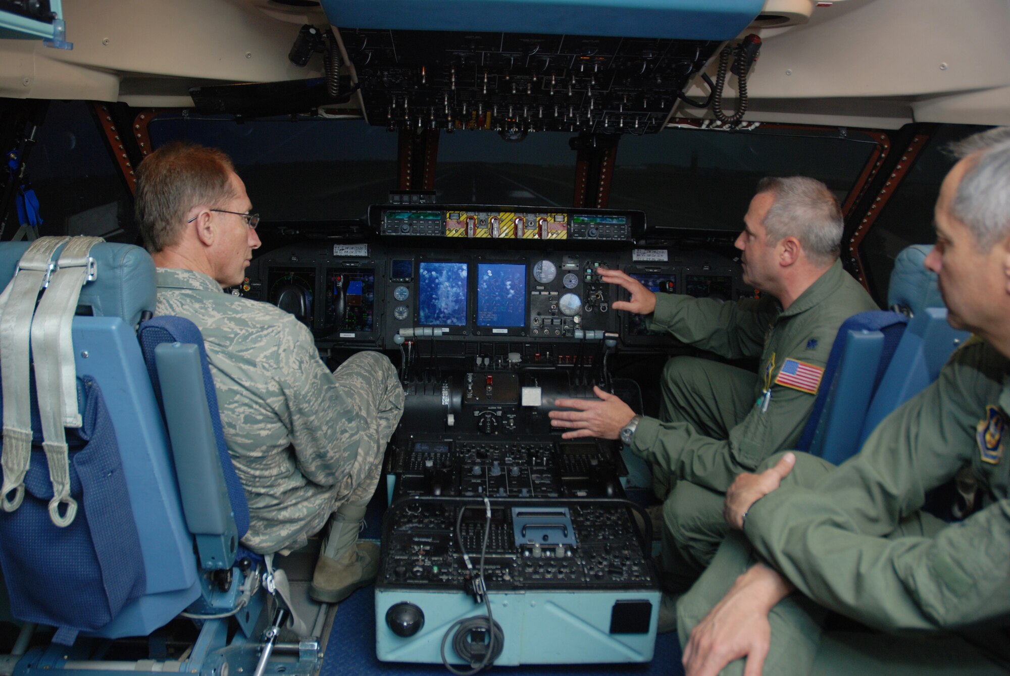Major Gen. James T. Rubeor, the 22nd Air Force commander, talks with Lt. Col. Jeffrey Hancock, 439th Operation Support Squadron commander, and Col. Robert Swain, the wing's commander, inside the C-5 flight simulator at Westover.