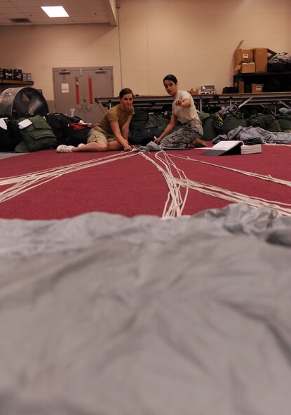 MOODY AIR FORCE BASE, Ga. -- Senior Airman Andrea Brandenberg, 38th Rescue Squadron logistics flight aircrew flight equipment journeyman, trains Airman 1st Class Caitlan Bunn, 38th RQS AFE apprentice, how to properly pack a free-fall parachute here May 10. Airmen Brandenberg and Bunn are just two of the 11 Airmen that pack parachutes for the 38th RQS. (U.S. Air Force photo by Airman 1st Class Benjamin Wiseman/RELEASED)