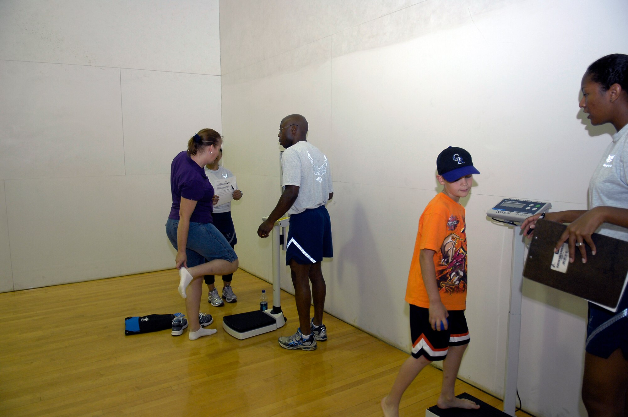 Participants in the Fit Family Health Fair at the Pope Fitness Center have their weight taken as part of their health assessment May 8. The health assessment was one of several tools provided to fair-goers to help improve their health and fitness. (U.S. Air Force photo/Senior Airman Kris Levasseur)