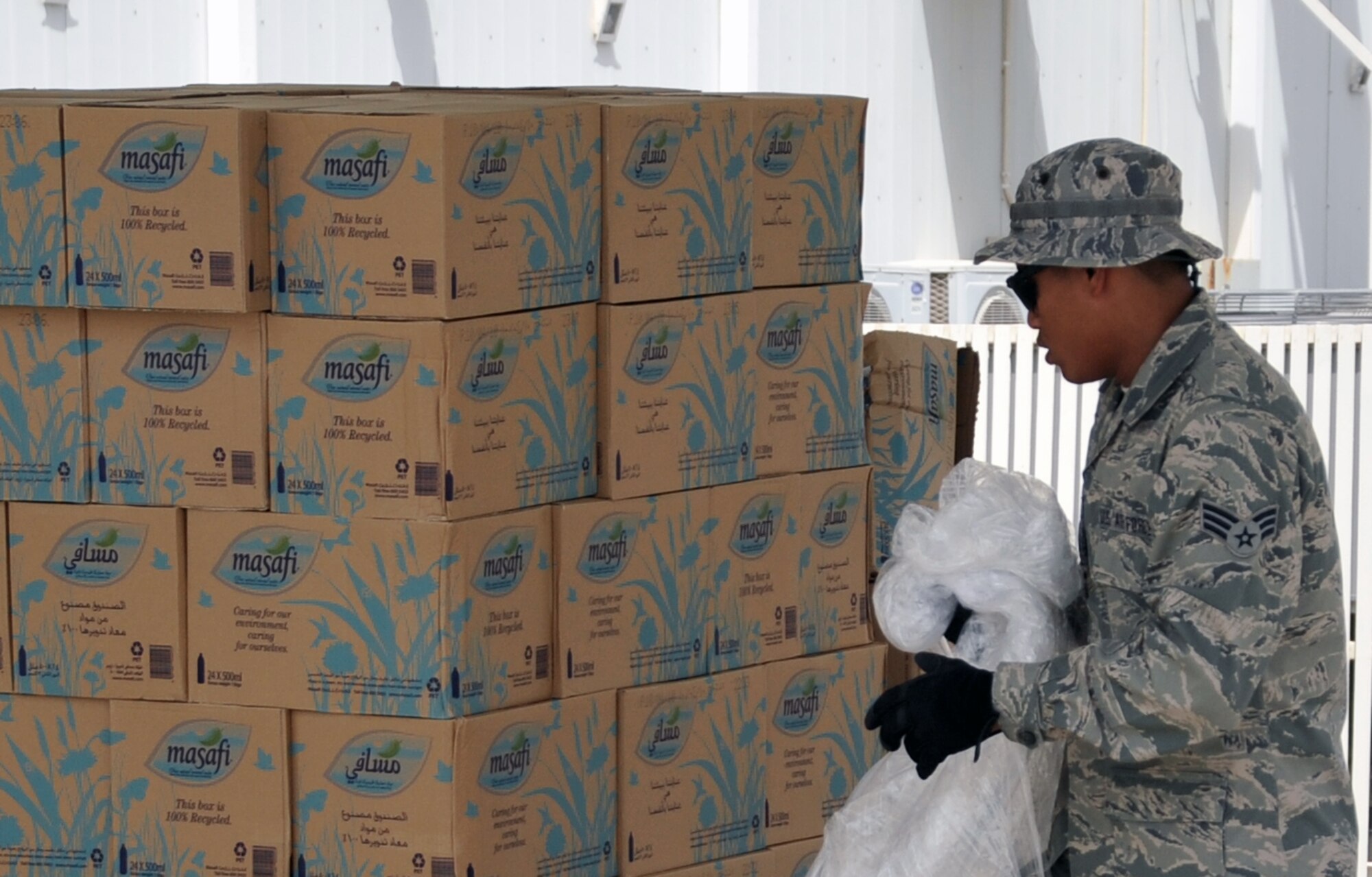 Senior Airman Justin Bayudan, services journeyman assigned to the 380th Expeditionary Force Support Squadron, unwraps plastic from a pallet of water during operations for the 380th Air Expeditionary Wing at a non-disclosed base in Southwest Asia on April 27, 2010. Airman Bayudan is an Air National Guard Airman deployed from the 154th Force Support Squadron at Hickam Air Force Base, Hawaii. His hometown is Waipahu, Hawaii. (U.S. Air Force Photo/Master Sgt. Scott T. Sturkol/Released)