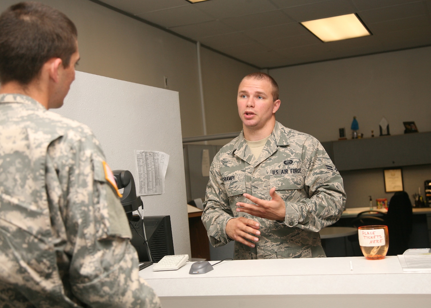 Airman 1st Class Cary Chiampi, 802nd Force Support Squadron, aids a Soldier with personnel questions May 4 at the Military Personnel Section. The MPS has focused its services around efficiency and ease for its customers, implementing measures such as online appointment scheduling for Common Access Cards and numerous basewide branch locations. (U.S. Air Force photo/Robbin Cresswell)