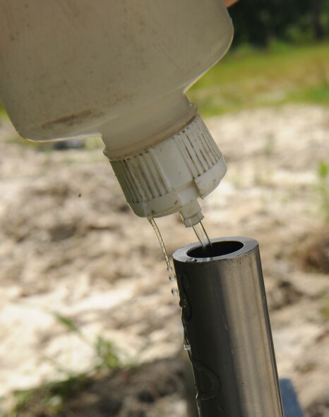 MOODY AIR FORCE BASE, Ga. -- Water is poured into the barrel of a percussion actuated neutralizer device here May 12. The PAN device uses an explosive round to fire water or air at a high velocity onto a point target, causing disruption to the target’s circuitry. (U.S. Air Force photo by Airman 1st Class Benjamin Wiseman/RELEASED)