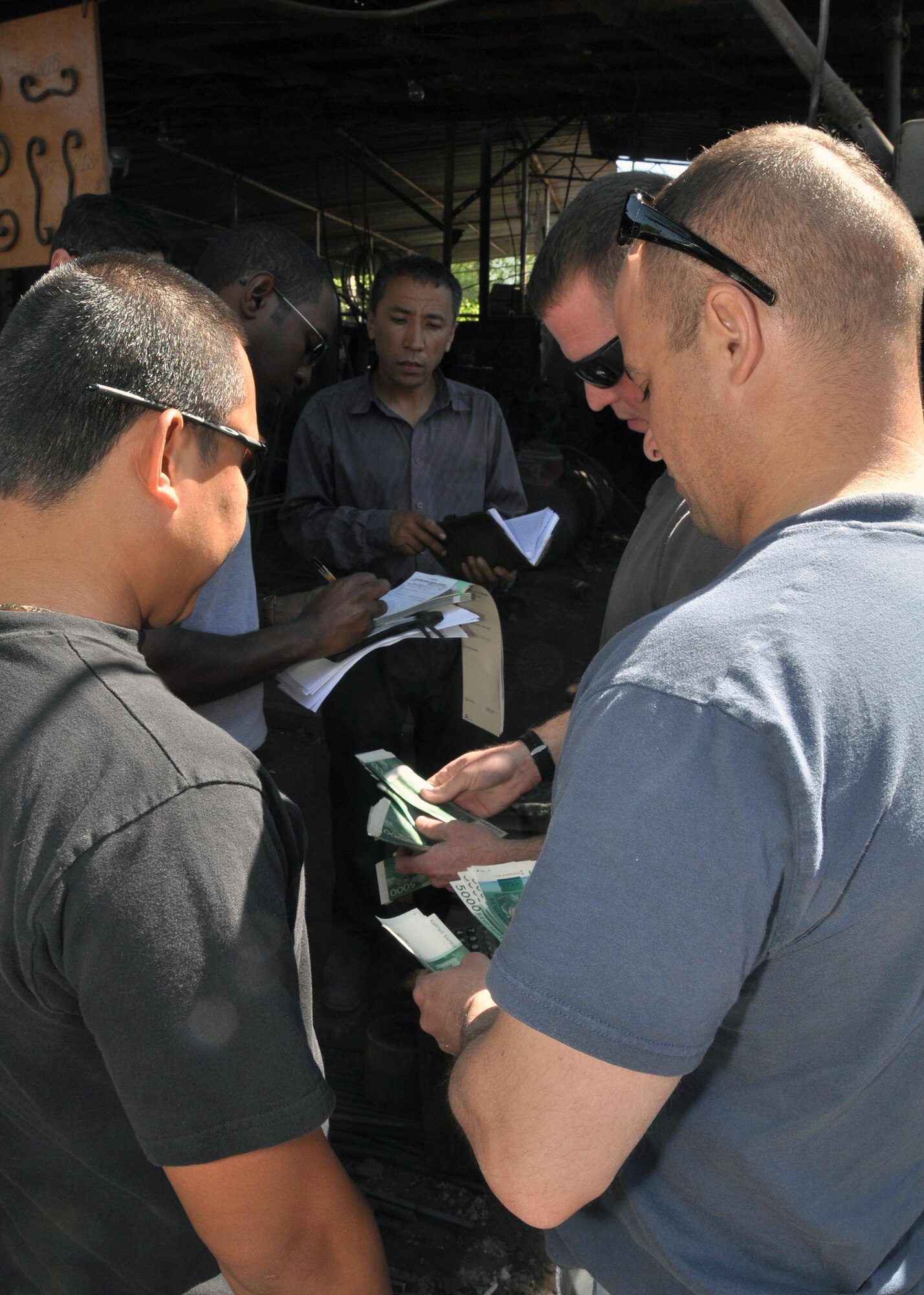 376th Expeditionary Civil Engineer Squadron civil engineers purchase fencing for a local school in a market, May 13, 2010. This team of six regularly does CE-related humanitarian assistance in many places in Kyrgyzstan. (U.S. Air Force photo/Staff Sgt. Carolyn Viss)