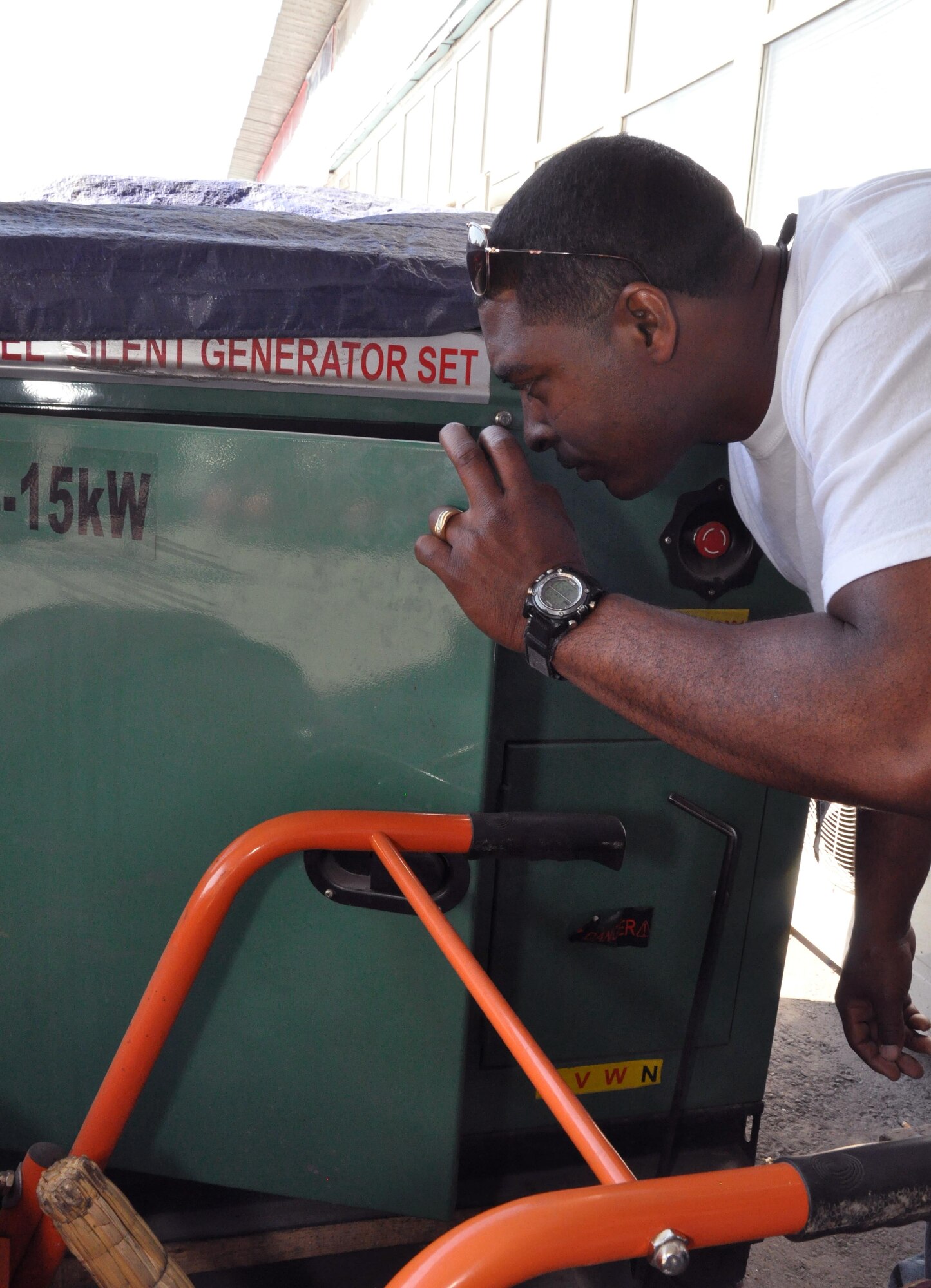 Staff Sgt. Dantrell Walker looks inside a generator prior to purchase May 13, 2010, in a local market outside the Transit Center at Manas, Kyrgyzstan. Sergeant Walker is part of the 376th Expeditionary Civil Engineer Squadron quality assurance flight, and his team of six regularly does CE-related humanitarian assistance all over northern Kyrgyzstan. (U.S. Air Force photo/Staff Sgt. Carolyn Viss)