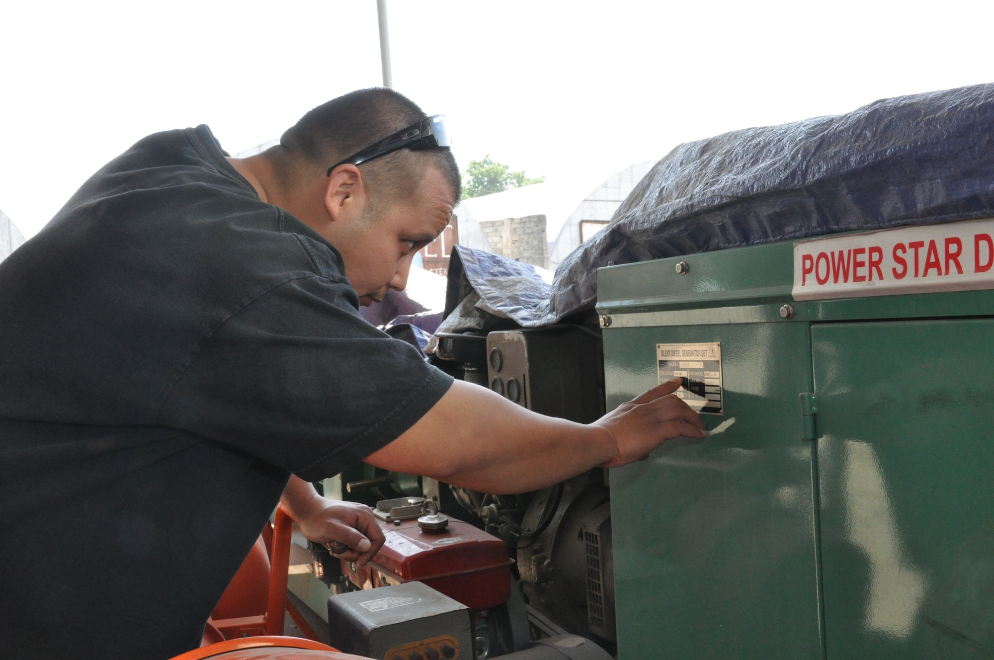 Tech. Sgt. Joseph Naputi checks out the specifications on a generator prior to purchase May 13, 2010, in a local market outside the Transit Center at Manas, Kyrgyzstan. Sergeant Naputi is part of the 376th Expeditionary Civil Engineer Squadron quality assurance flight, and his team of six regularly does CE-related humanitarian assistance all over northern Kyrgyzstan. (U.S. Air Force photo/Staff Sgt. Carolyn Viss)