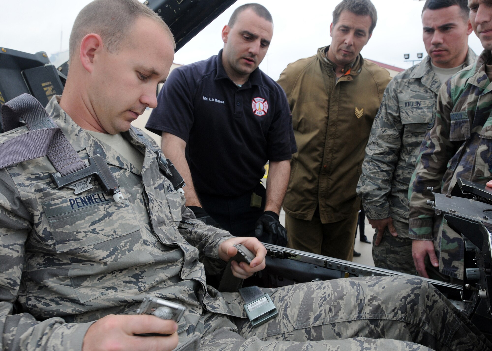 Staff Sgt. Jason Penwell, 31st Civil Engineer Squadron firefighter, shows Aviano and Italian Air Force firefighters how to operate the seatbelt in an F-16 Fighting Falcon May 10 as part of an annual F-16 emergency response action training.  The Aviano community can rest assured in knowing that the firefighters at Rivolto Airport are properly trained on the correct procedures to save the lives of our pilots and aircraft.  (U.S. Air Force photo/ Senior Airman Tabitha M. Mans)