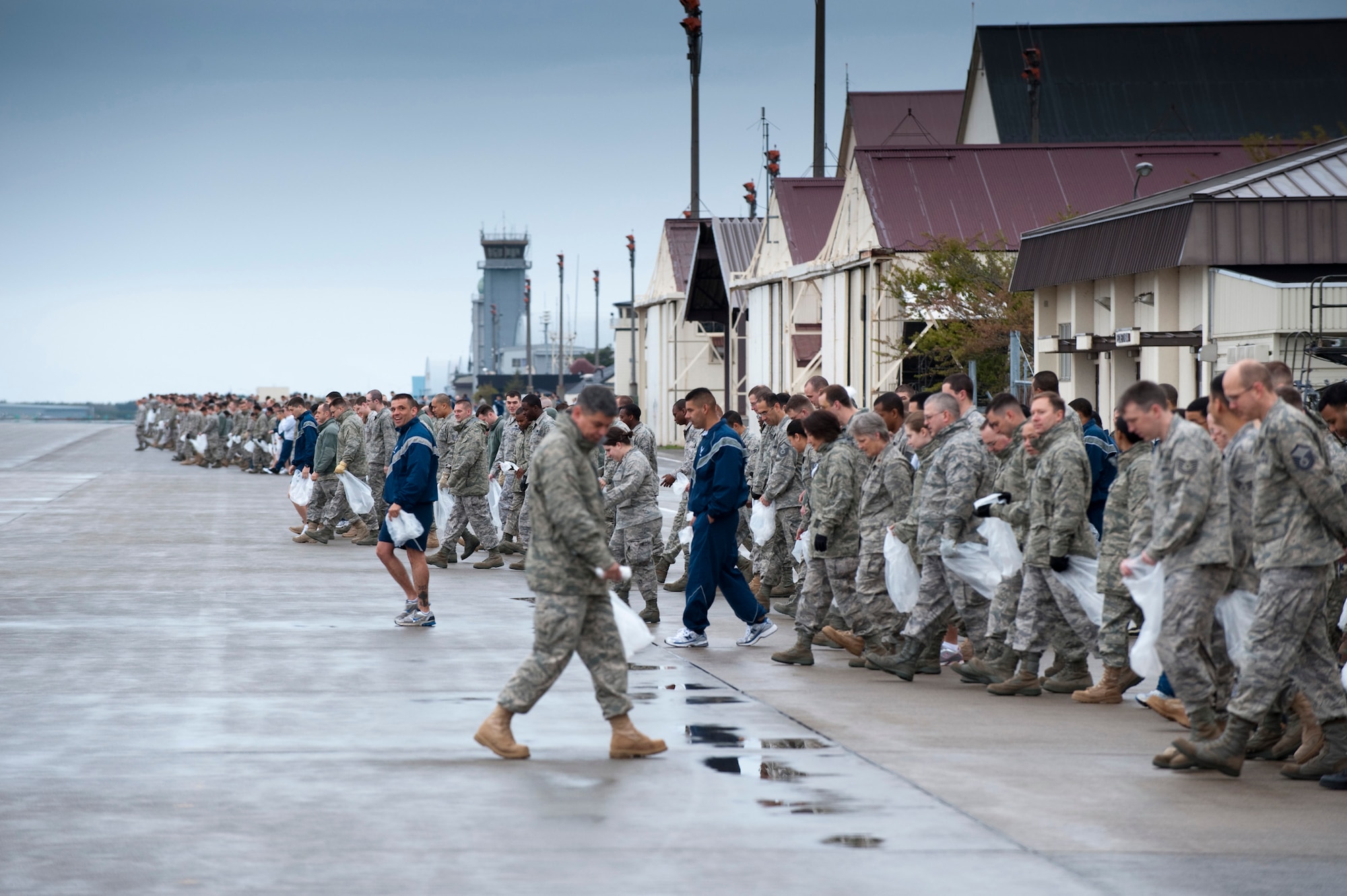 MISAWA AIR BASE, Japan -- In the pale morning light, approximately 550 Airmen and Sailors from Misawa Air Base begin clearing the runways and taxiways of debris that could potentially cause foreign-object damage to jets on the flightline as part of the annual FOD walk May 14. The joint-service team collected an estimated 500 pounds of debris in less than an hour, allowing the flightline to resume operations by 7 a.m. (U.S. Air Force photo/Staff Sgt. Samuel Morse)