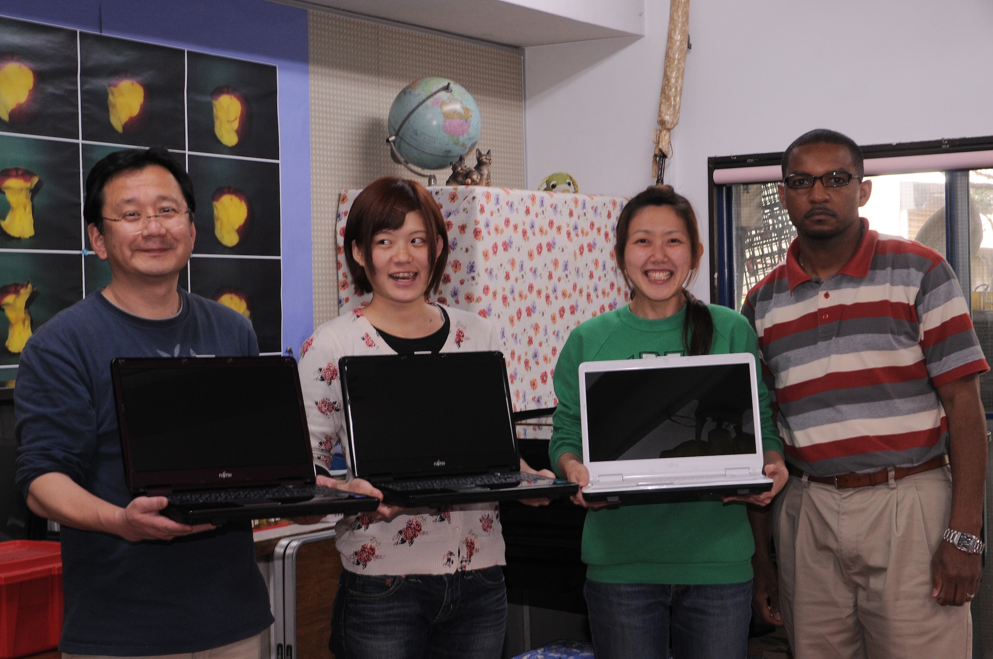 YOKOTA AIR BASE, Japan -- Employees at the Aiji no Ie orphanage gladly accept new laptop computers from Mr. Kendall Carter.  Aiji no Ie translated means House of Affection. The orphanage has 36 children ranging in ages from 2 to 17. (U.S. Air Force photo/ Airman 1st Class Lynsie Lorenz)