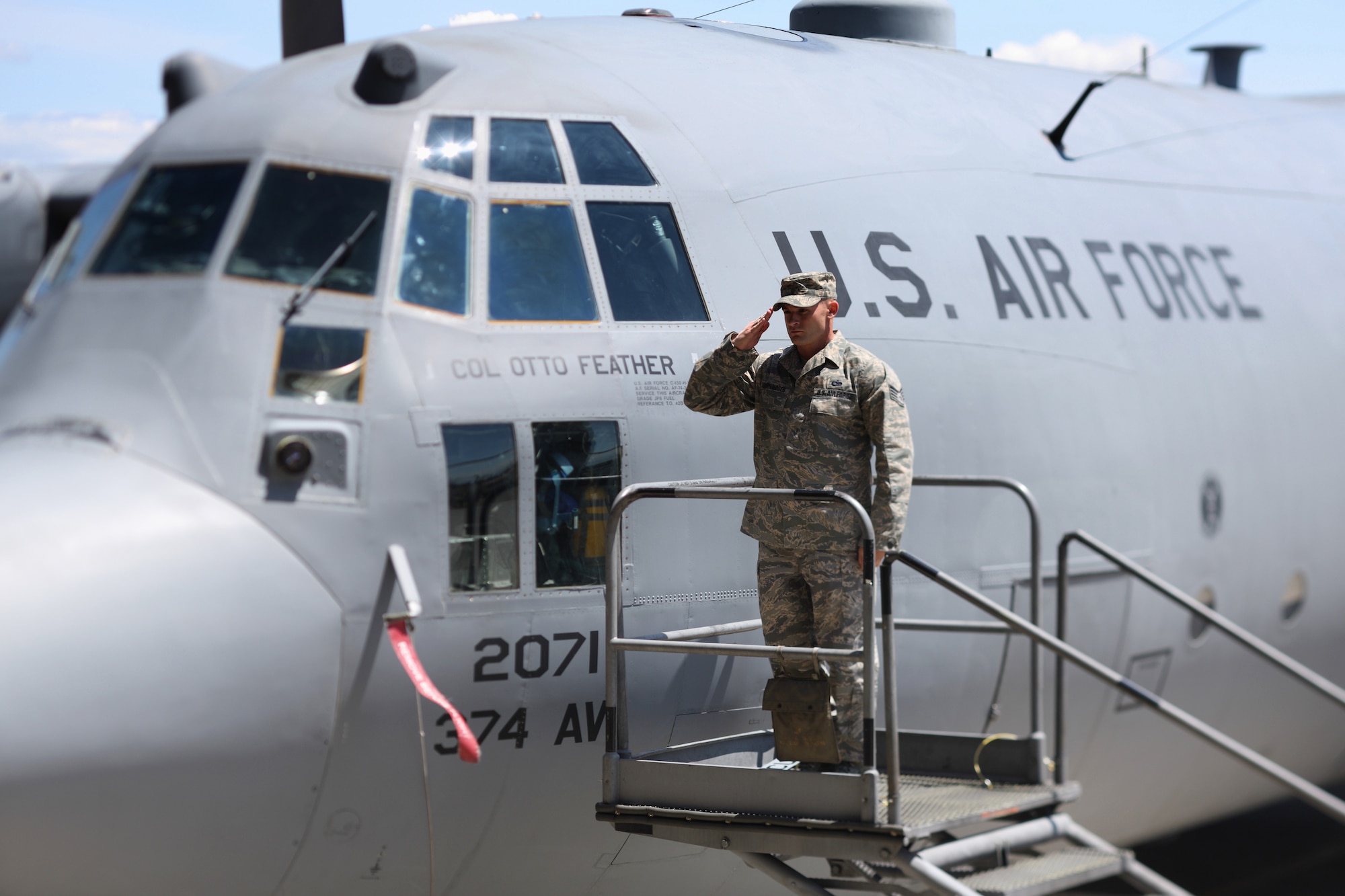 YOKOTA AIR BASE, Japan -- Staff Sgt. Tyson Schoenmoser, 374th Aircraft Maintenance Squadron, salutes Col. Otto Feather after revealing the commander's name on a C-130 Hercules May 14, during the 374th Airlift Wing Change of Command ceremony. (U.S. Air Force photo/Osakabe Yasuo)