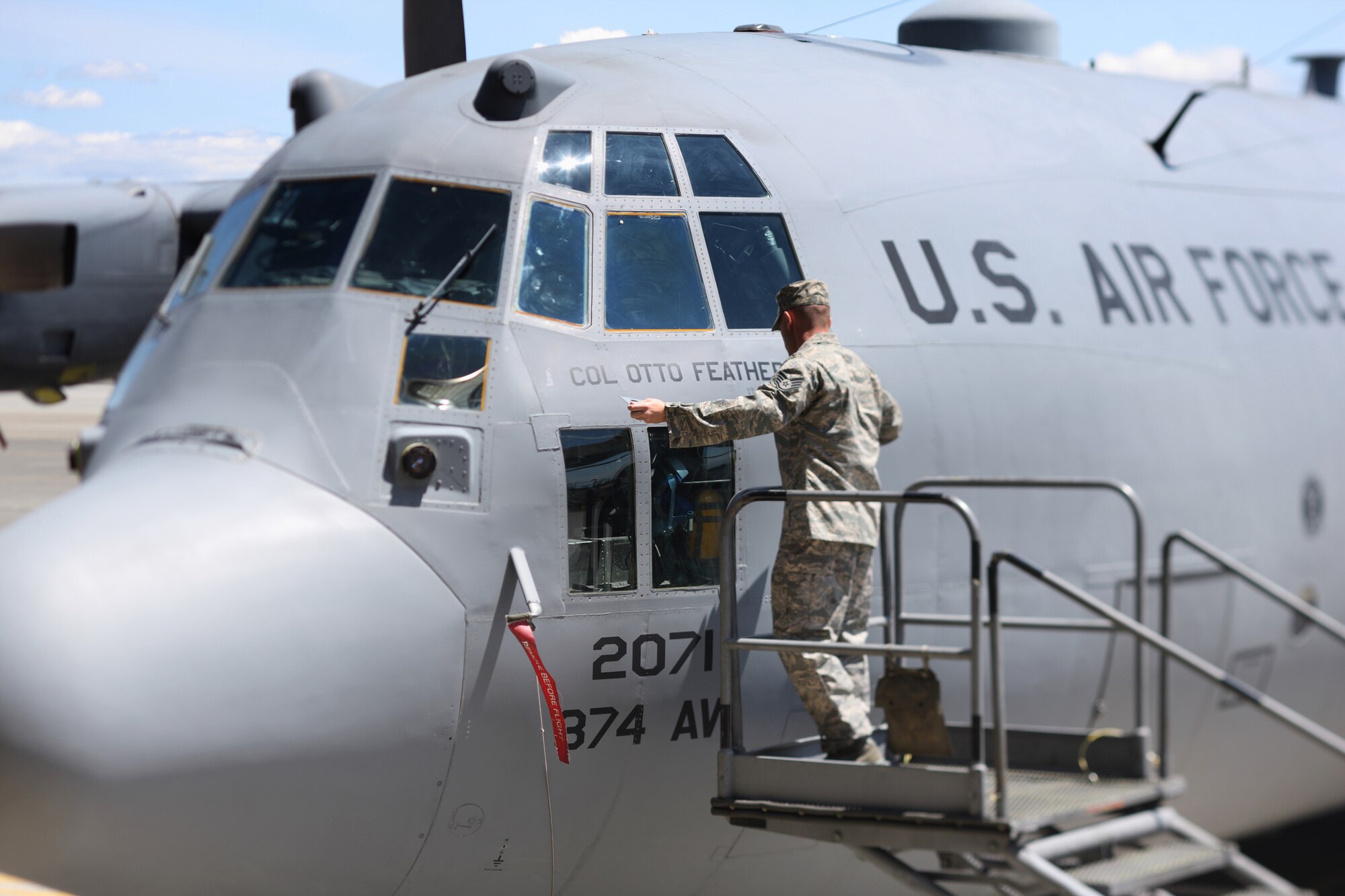 YOKOTA AIR BASE, Japan -- Staff Sgt. Tyson Schoenmoser, 374th Aircraft Maintenance Squadron, reveals the name of the new 374th Airlift Wing commander, Col. Otto Feather, during the 374th Airlift Wing Change of Command ceremony here May 14. (U.S. Air Force photo/Osakabe Yasuo)