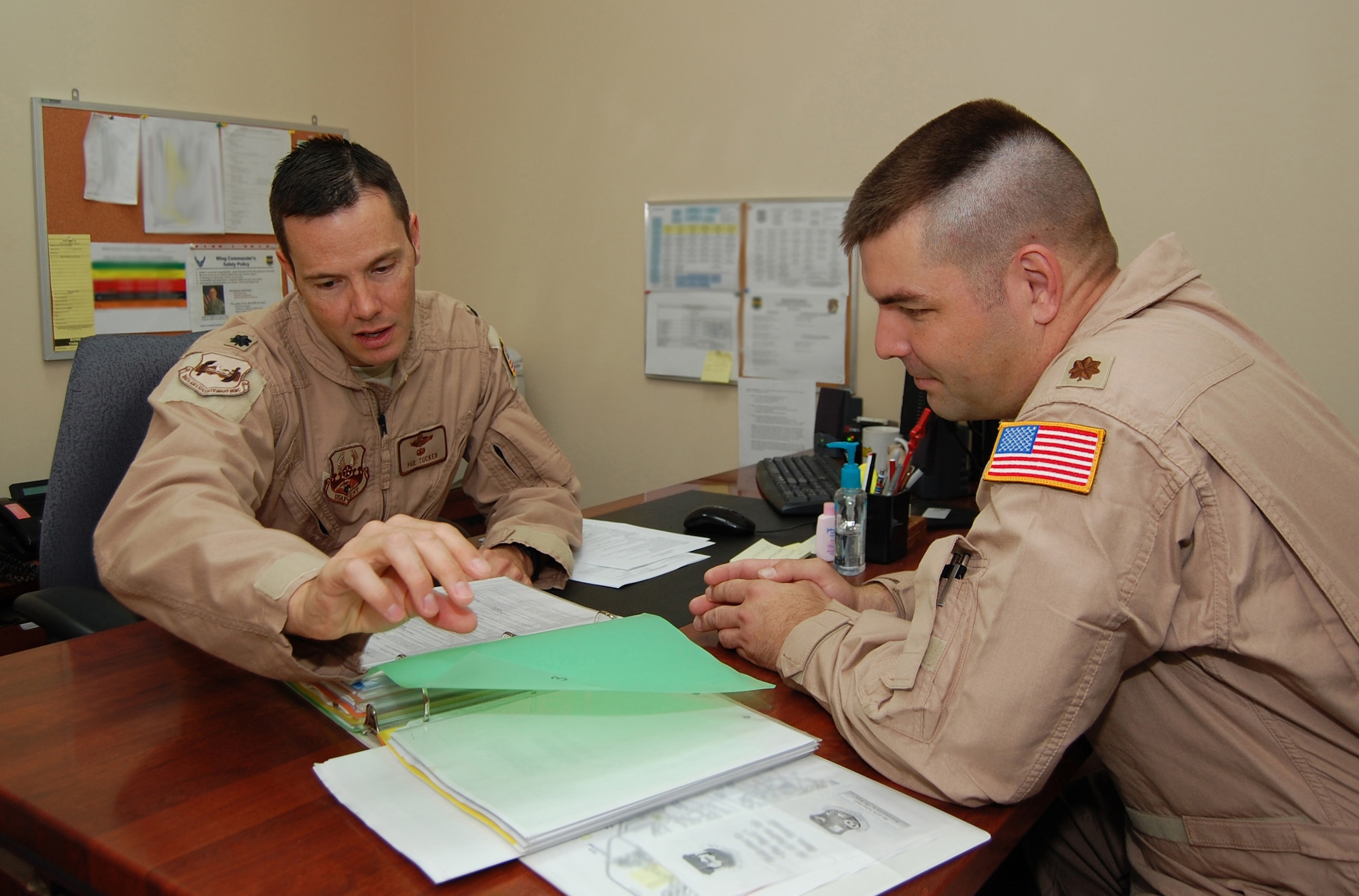 From left, U.S. Air Force Lt. Col. Phillip Tucker, 386th Air Expeditionary Wing Safety chief, discusses continuity and words of wisdom with his replacement Maj. Jacob Rosser May 12, 2010 at an air base in Southwest Asia. The Safety office consists of ground, flight and weapons safety sections.  (U.S. Air Force photo illustration by Staff Sgt. Lakisha A. Croley/Released)