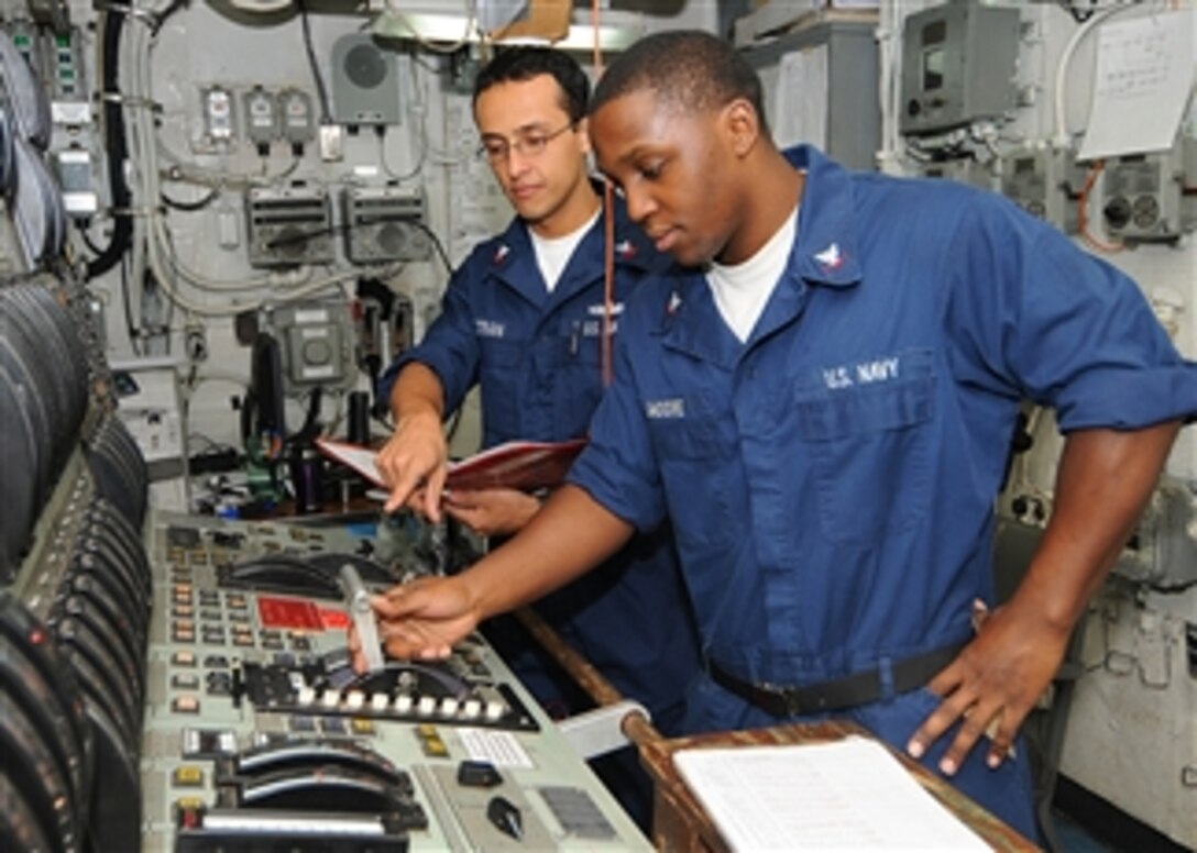 U.S. Navy Petty Officer 2nd Class Alberto Beltran-Lopez provides training on the main propulsion console to Petty Officer 3rd Class Marcus J. Moore aboard the dock landing ship USS Ashland (LSD 48) in the U.S. 5th Fleet area of responsibility on May 3, 2010.  The Ashland is part of the Nassau Amphibious Ready Group supporting maritime security operations and theater security cooperation operations.  