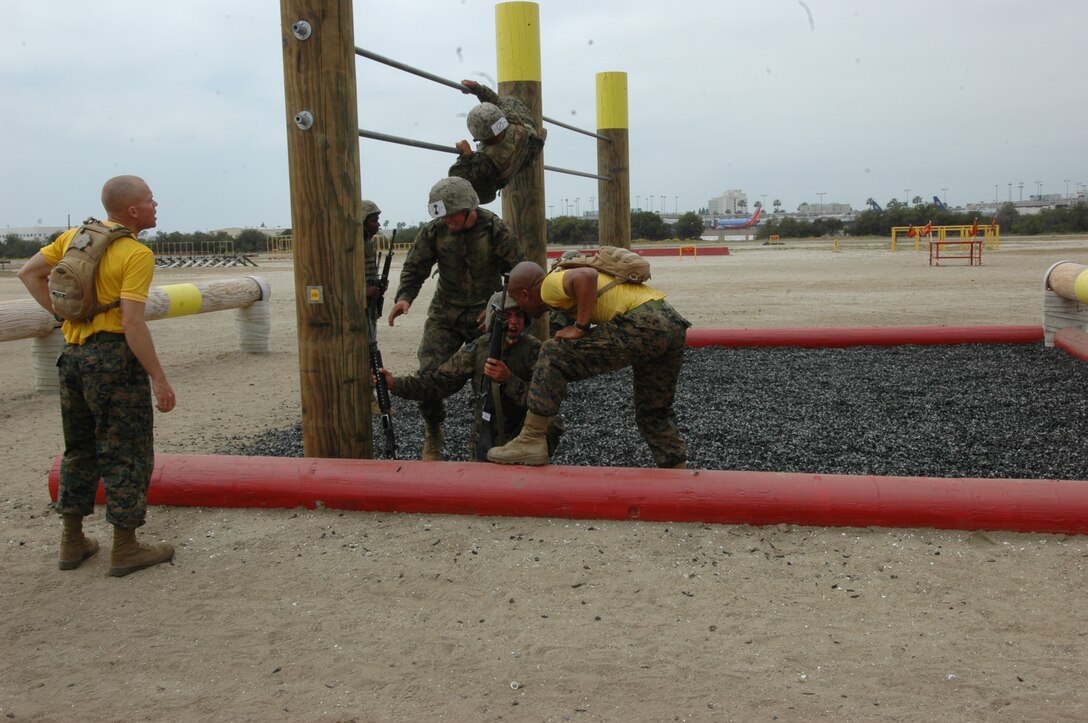 Company E Marines receive words of encouragement from their drill instructors as they maneuver the last few obstacles of the course on the depot, May 15.