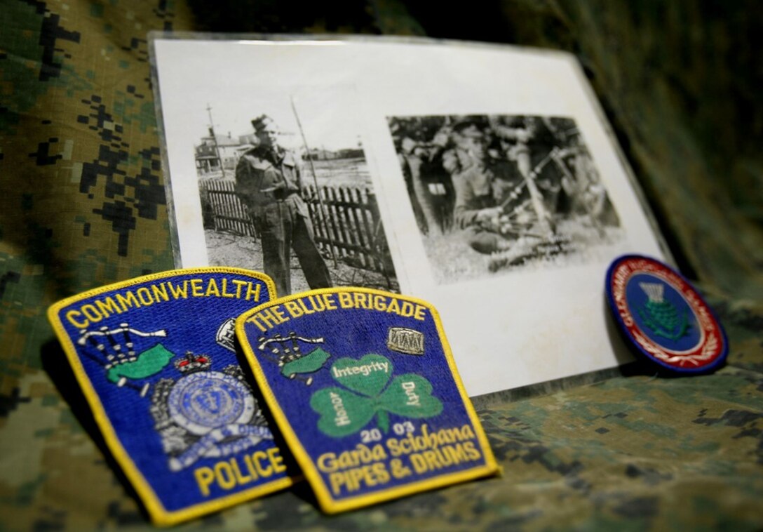 Lance Cpl. Rory MacEachern, a military policeman with Combat Logistics Battalion 6, 1st Marine Logistics Battalion (Forward) displays patches from various organizations he has performed with throughout his 13-year span as a bagpipe musician. Also shown are photographs of his grandfather as a soldier in World War II (left) and his great grandfather, a bagpiper in the Canadian Army during World War I.