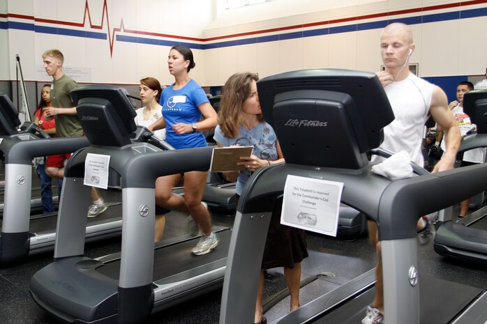 Competition observers watch over Lance Cpl. Kyle Vander Molen, a station operations competitor, 2nd Lt. Katherine Kleese, a Headquarters and Headquarters Squadron competitor and Sgt. Michael Knight, a Marine Wing Support Squadron 171 competitor, during the two-mile triathlon portion of the 2010 Commander’s Cup Indoor-Triathlon at the IronWorks Gym here May 14. Marine Aviation Logistics Squadron 12 took first place with a time of 27 min. 18 sec., while the Robert M. Casey Medical and Dental Clinic claimed second with a time of 28 min. 20 sec and MWSS-171 won third with a time of 28 min. 21 sec.