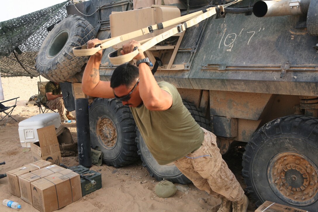 Staff Sgt. Jose E. Garcia, the communications chief for Alpha Co., 2nd Light Armored Reconnaissance Battalion, uses Training Exercise Straps of the side of his vehicle the deserts of Helmand province, Afghanistan, May 16. The vehicle was not only their home and gym over the battalion’s five-month deployment, but it also served the battalion’s combat operations center.