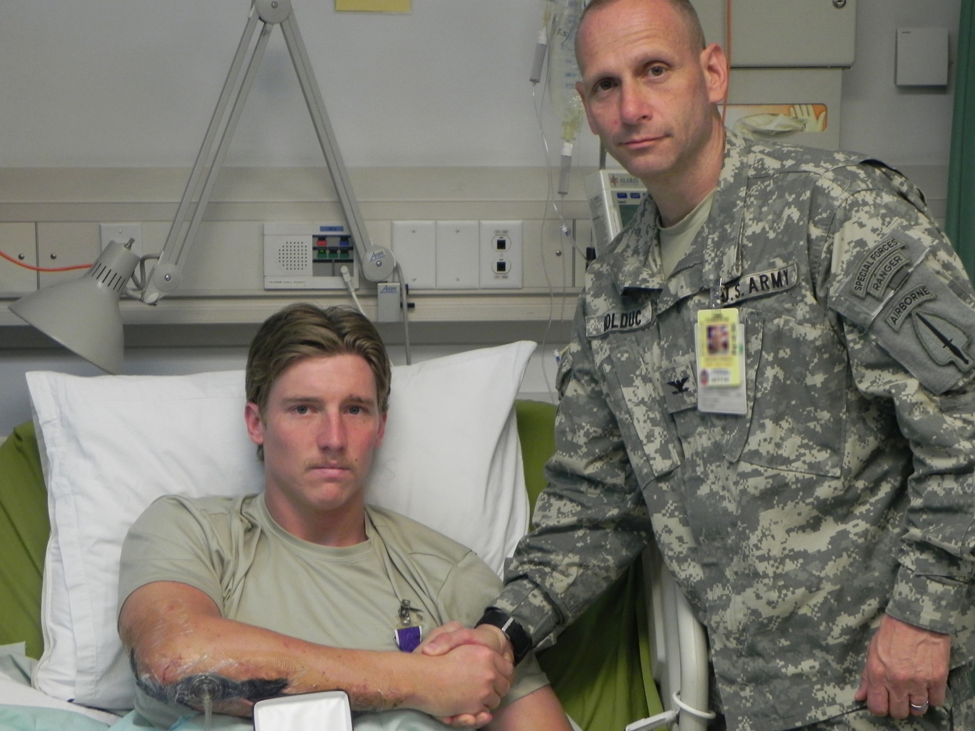 BAGRAM AIRFIELD, Afghanistan -- Staff Sgt. Travis Dalton, a combat controller with the 320th Special Tactics Squadron, shakes hands with Col. David Buldoc, Combined Joint Special Operations Task Force-Afghanistan commander, after receiving the Purple Heart at Craig Joint Theater Hospital here May 10.  Sergeant Dalton was wounded in his right arm, hamstrings and buttocks May 8 when an improvised explosive device detonated near him during a dismounted combat patrol in Helmand Province in Afghanistan. (Courtesy photo)                               