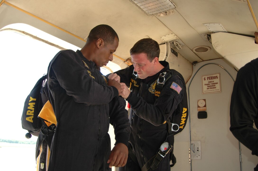 JOINT BASE ANDREWS, Md. - Members of the US Army Golden Knights assist each other with their gear before preflight at the Andrews Airshow May 15. The Golden Knights is one of the many performers of this years’ Joint Service Open House.  Their full show consists of four separate maneuvers, which demonstrate the maneuverability of the human body while falling at speeds in excess of 120 mph. (US Navy photo by Mass Communication Specialist Second Class George Trian)