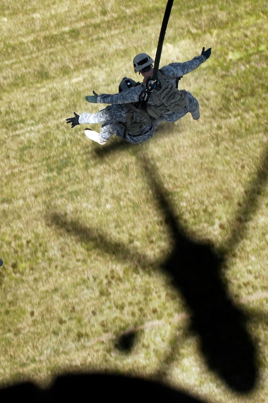 JOINT BASE ANDREWS, Md. - U.S. Army Special Forces soldiers from the 7th Special Forces Group (airborne) use the Fast Rope Infiltration/Exfiltration System to quickly evacuate the landing area. A Special Operations UH-60 Blackhawk Aircraft lowers the FRIES rope system to the soldiers, who latch on as a group and are airlifted, suspended below the aircraft. The demonstration is part of the Joint Service Open House 2010 here May 14-16. (U.S. Air Force photo by Senior Airman Melissa V. Brownstein)