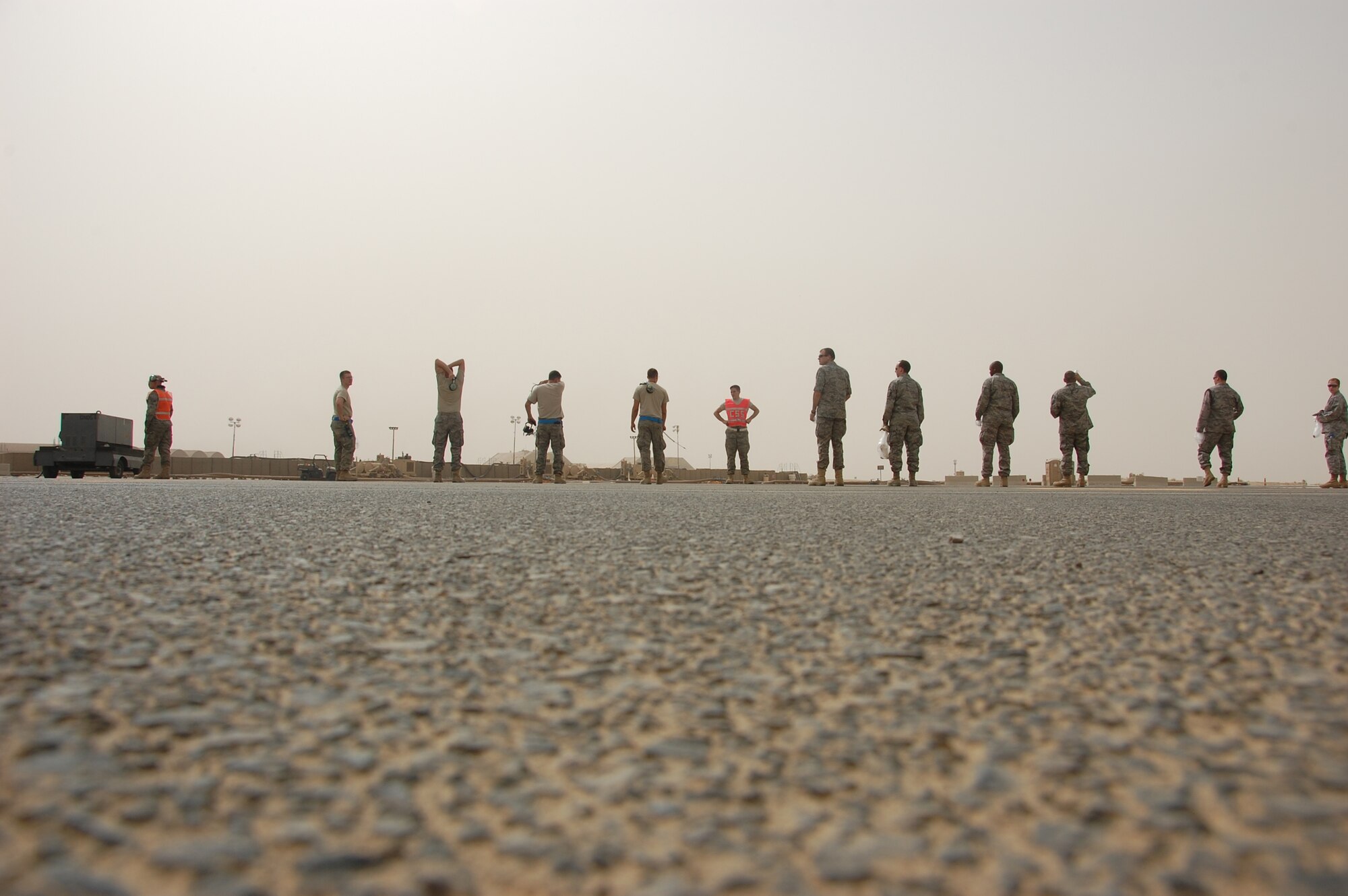 SOUTHWEST ASIA - U.S. Air Force members deployed with the 386th Air Expeditionary Wing line up for a foreign object debris walk on the base airfield here May 15, 2010. Airmen participate in the FOD walk quarterly to ensure trash and other debris remains clear of the airfield to prevent damage to aircraft engines. (U.S. Air Force photo by Staff Sgt. Lakisha A. Croley/Released)