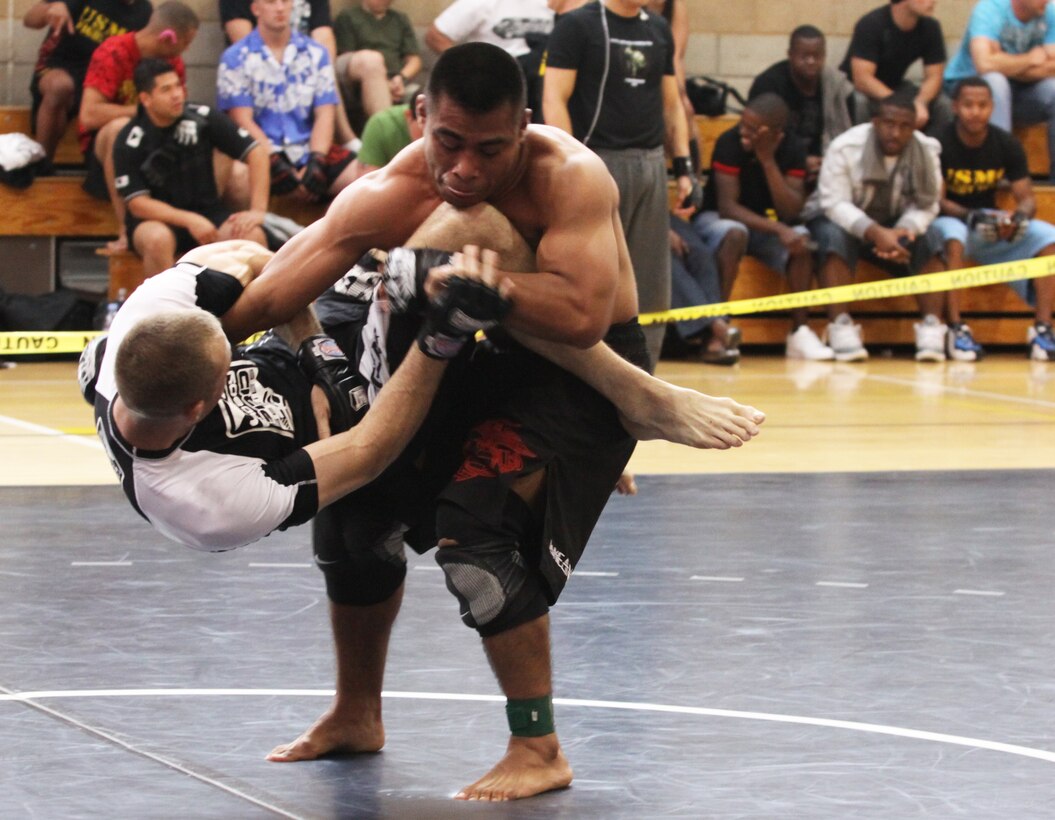 Cpl. David Torres (right), supply clerk, Alpha Company 1st Marine Logistics Group, lifts up his opponent, Sgt. Bryce Jensen, administrative clerk, 5th Marine Regiment, during the 6th Annual Pankration Tournament at Camp Pendleton’s Paige Fieldhouse , May 15. Pankration is a competition where members of different teams battle each other utilizing styles often seen during Mixed Martial Arts events. Torres took first place in the varsity 146-155 pound weight class.