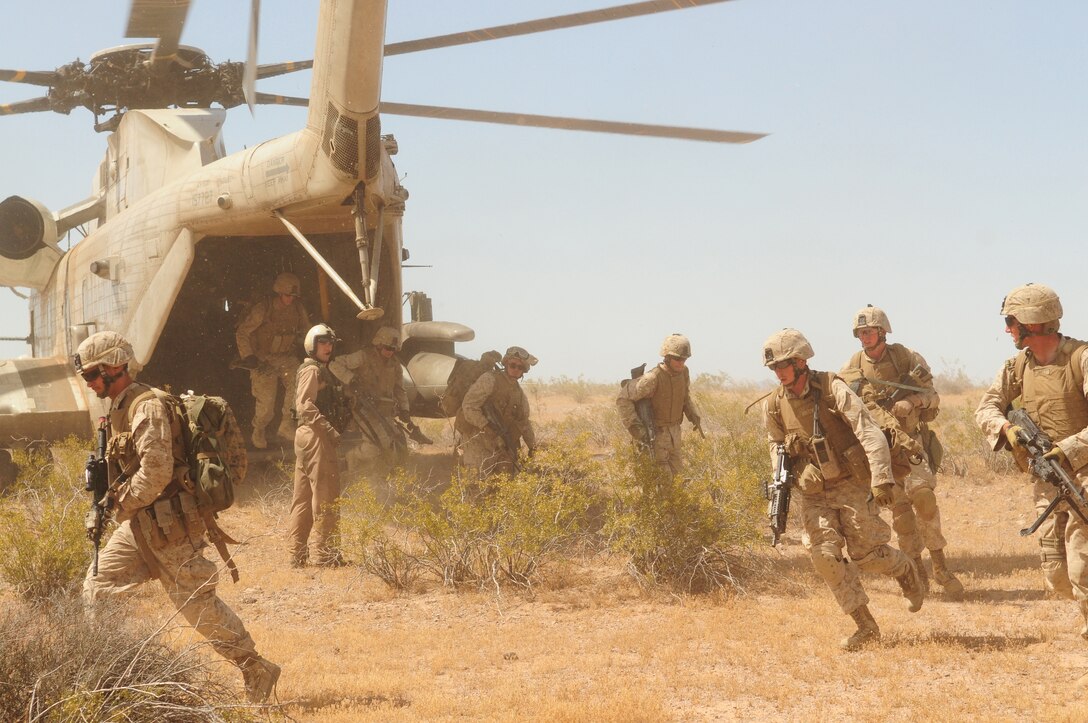 Marines with Company A, 1st Battalion, 1st Marine Regiment, unload from a CH-53D Sea Stallion during a helicopter raid at the Barry M. Goldwater Range May 15, 2010. After being dropped off the range, the Marines divided themselves into three task-oriented platoons. The Marines used 360-degree security to cover the assault and support elements of the company as they opened fire on a simulated insurgent camp. The raid was their final exercise for the Weapons and Tactics Instructor course taught by Marine Aviation Weapons and Tactics Squadron 1 at the Marine Corps Air Station in Yuma, Ariz.