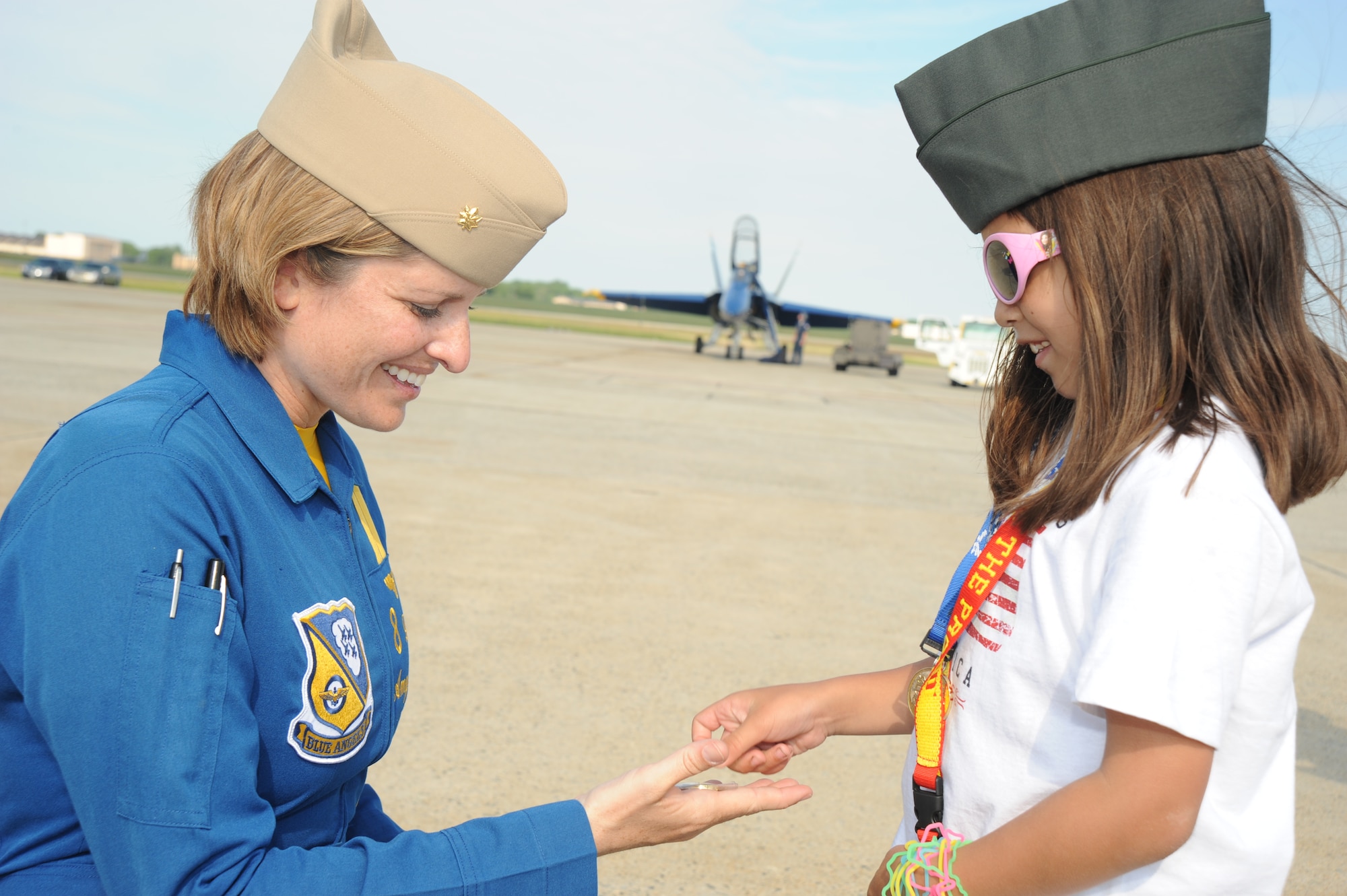 JOINT BASE ANDREWS, Md. - Lt. Cmdr. Amy Tomlinson, the events coordinator for the Navy Blue Angels, receives a coin from Rizzy Wieser, a nine year-old girl who traveled from Florida to say thank you to service members at the Joint Service Open House here May 16. JSOH allows members of the public an excellent opportunity to meet and interact with the men and women of the Armed Forces. (U.S. Air Force photo by Staff Sgt. Christopher Marasky)