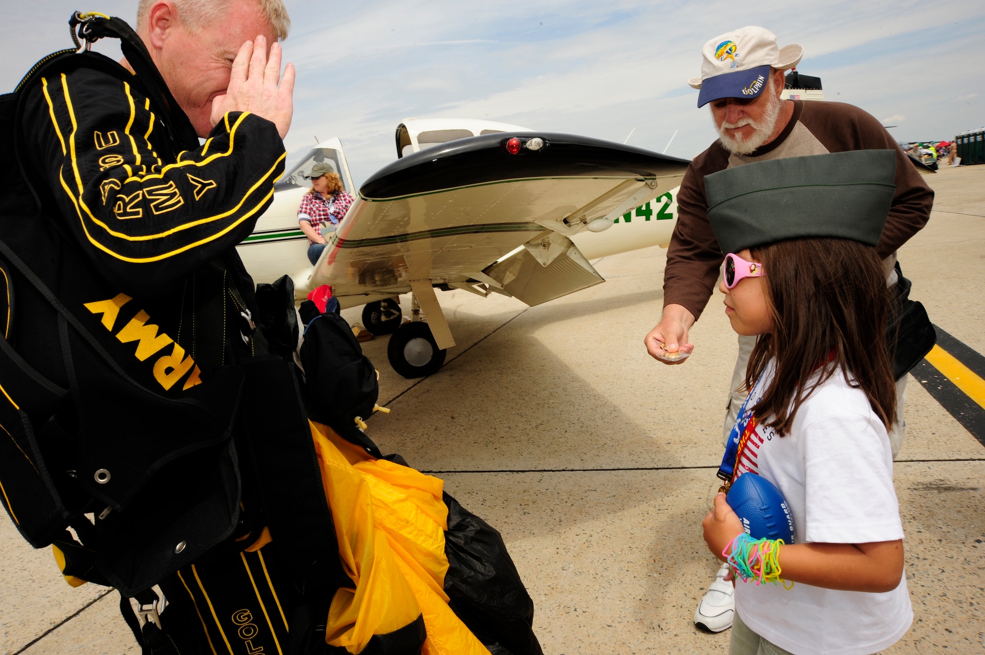 Joint Base Andrews, Md. -- An Army Golden Knight Parachutist salutes nine-year-old Rizzy Wieser during Joint Service Open House here May 16. With her father's assistance, Rizzy presents the Golden Knight with a coin thanking him for his service. JSOH allows members of the public an excellent opportunity to meet and interact with the men and women of the Armed Forces. (U.S. Air Force photo by Staff Sgt Keyonna Fennell)
