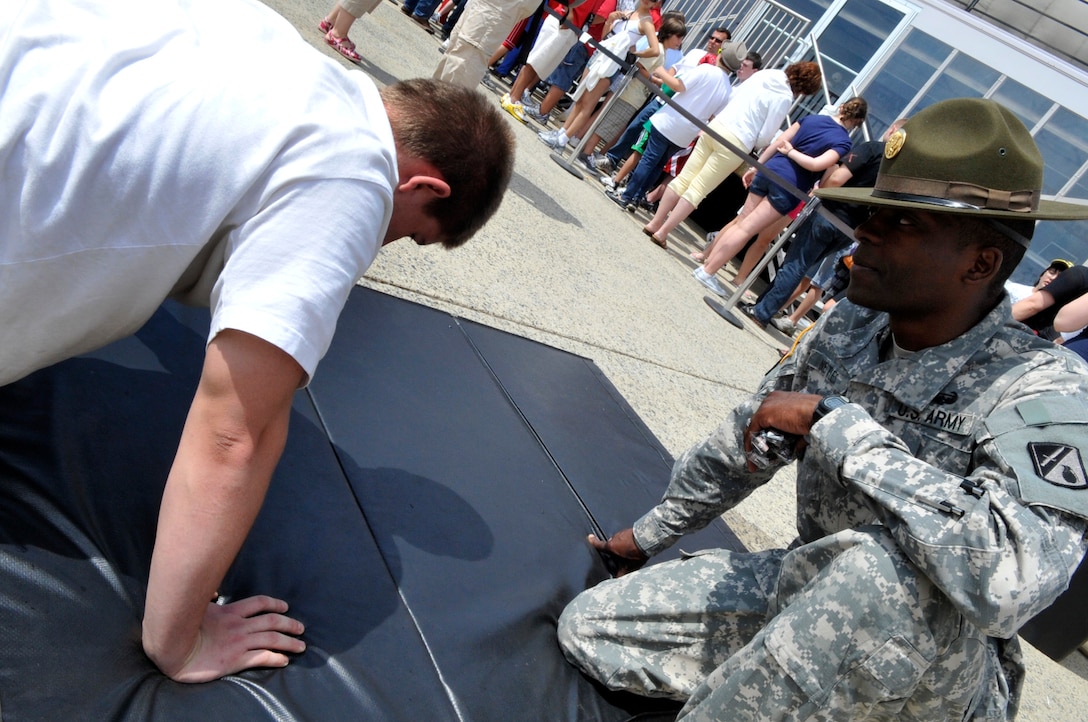 JOINT BASE ANDREWS, Md. - Army Staff Sgt. Jermarcus Nettles, a drill sergeant from Fort Benning, Ga., encourages AJ Armiger to do more pushups at the Army fitness challenge display at the Joint Service Open House here May 16. JSOH offers an opportunity for service members to interact with, thank and show the public America's skilled military. (U.S. Air Force photo by Staff Sgt. Renae L. Saylock)