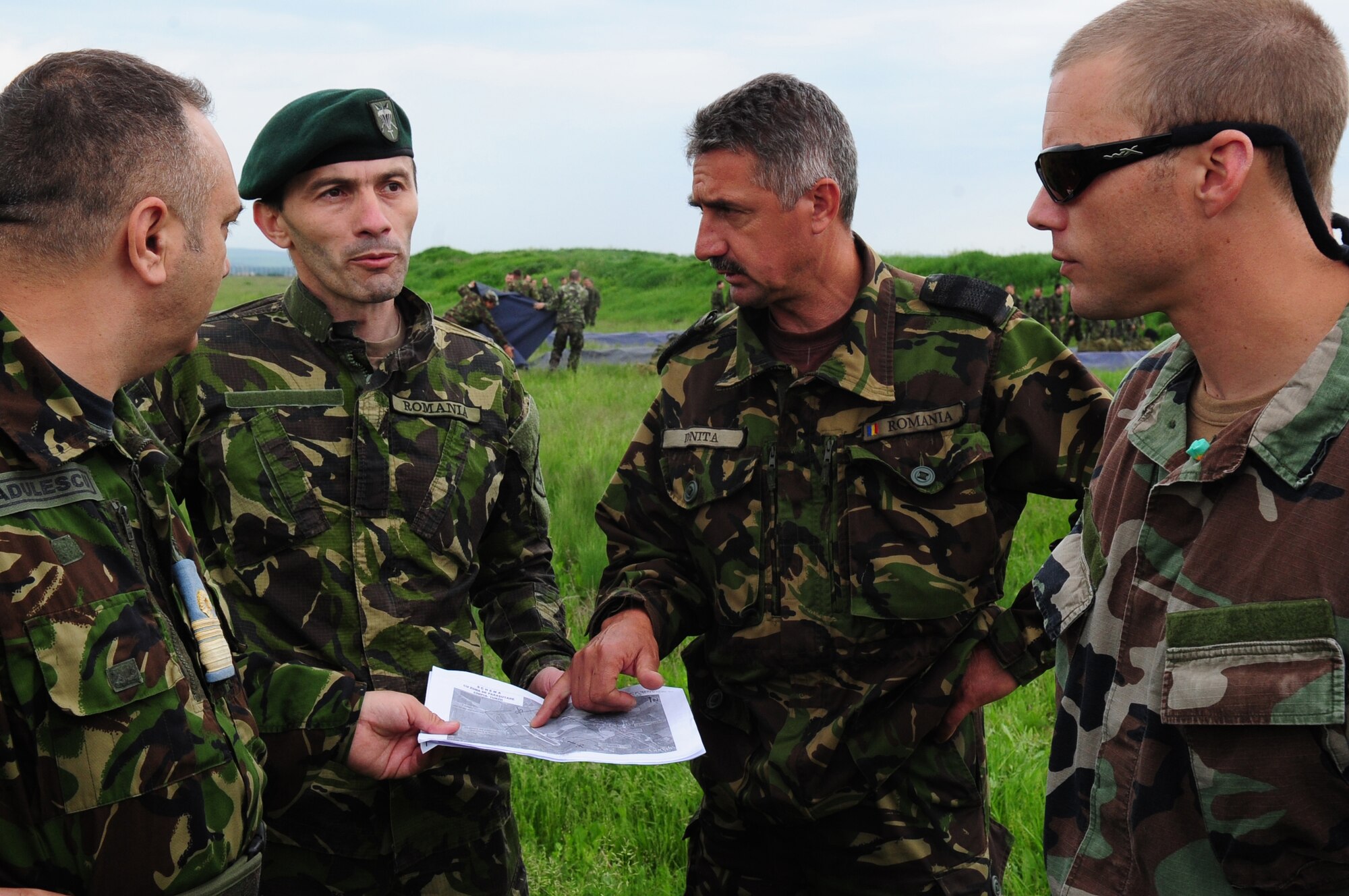Members of the Romanian Air Force and U.S. Navy Chief Petty Officer James Endicott, Explosive Ordinance Disposal Mobile Unit 8 aircrew survival equipmentman, discuss the drop zone for Romanian paratroopers preparing to jump from a U.S. Air Force C-130J during exercise Carpathian Summer, Camp Turzii, Romania, May 13, 2010. Carpathian Summer 2010 was an exercise in which the Romanian Air Force invited members of the U.S. military to train with them on their soil and air space, to observe and practice, firsthand, operations in action. This exercise was designed to build partnerships between these nations in an effort to work together more efficiently during real world scenarios. (U.S. Air Force Photo by Staff Sgt. Jocelyn Rich)