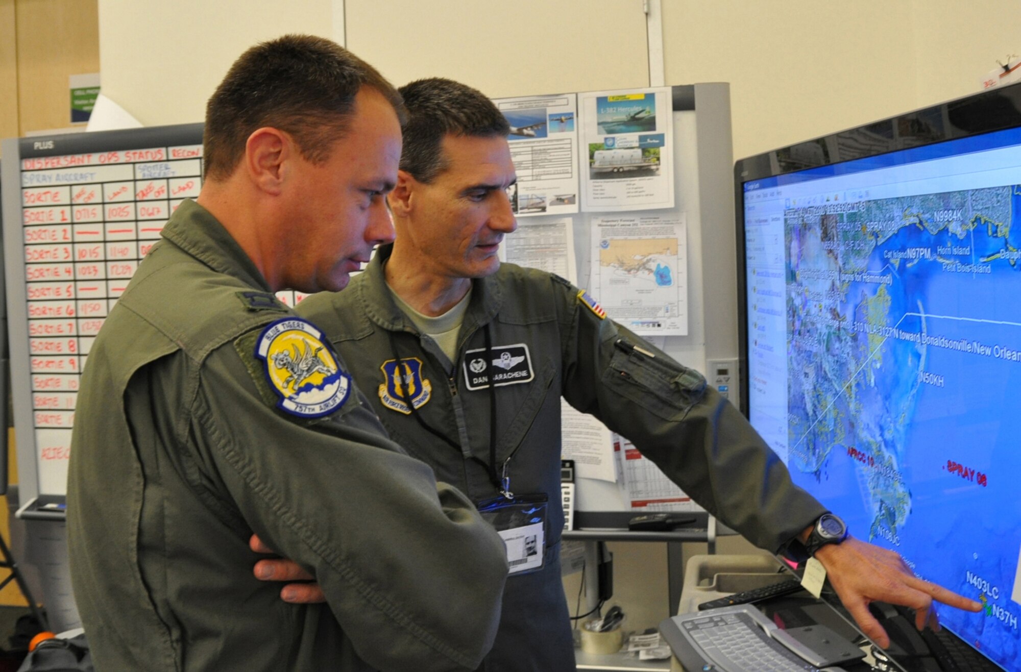 HOUMA, LA -- Air Force Reserve Lt. Col. Dan Sarachene (rear) reviews a map of the Gulf of Mexico with Capt. Travis Adams at the Incident Command Operations Center at the BP Training Center.  Capt. Adams prepares to relieve Lt. Col. Sarachene and continue service as a an Air Force liaison between the 910th Airlift Wing's aerial spray mission operations and BP oversight in response to the Deepwater Horizon oil spill mitigation.   The 910th Airlift Wing has been aerial spraying dispersant over the gulf oil slick since May 1.  U.S. Air Force photo/Maj. Brent Davis