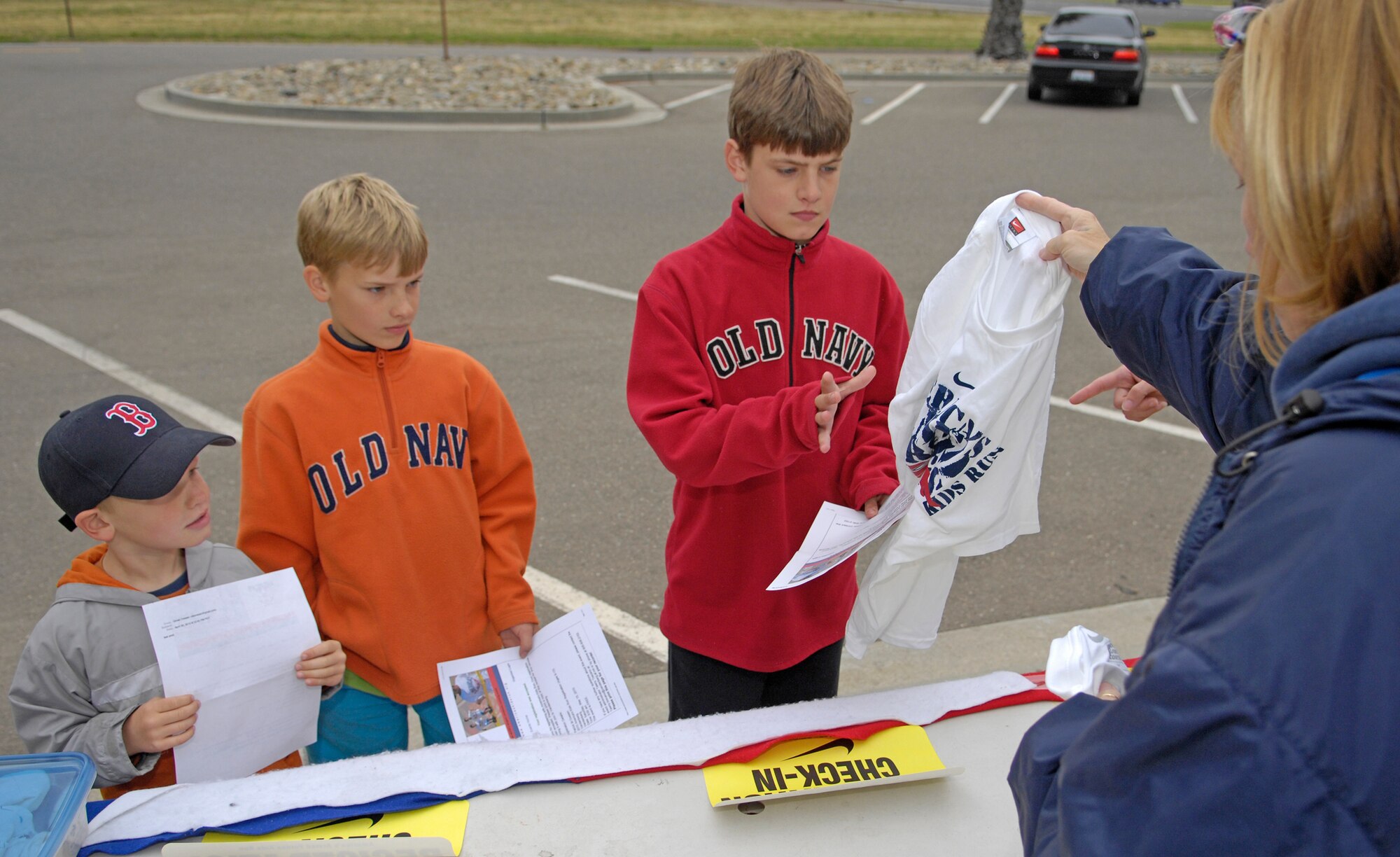 VANDENBERG AIR FORCE BASE, Calif. -- Noah, Patrick, Daniel Ovesen, sons of Senior Master Sgt. David Ovesen, from the 30th Space Communications Squadron, sign in at the registration booth and receive shirts for the Armed Forces Kids Run here Saturday, May 15, 2010. Children of Vandenberg AFB competed in the Armed Forces Kids Run at the base trail by the fitness center. Patrick Ovesen won first place in the race. (U.S. Air Force photo/Airman 1st Class Andrew Lee)