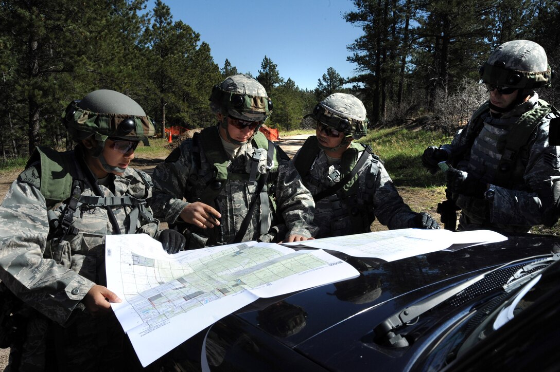 Space and Missile Systems Center's 61st Security Forces Squadron members from Los Angeles Air Force Base huddle for their strategy before the start of the tactics competition for Guardian Challenge 2010 May 15. (From left to right) DoD Officers Yvette Perez and Steven Haymes, Staff Sgt. Alex Andriyanov and Tech. Sgt. Rochanapan Silpe (Photo by Lou Hernandez)