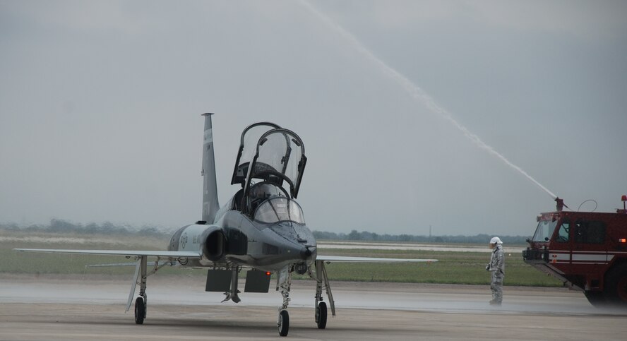 LAUGHLIN AIR FORCE BASE, Texas – A T-38 Talon aircraft piloted by Col. Jeffrey McDaniels, 47th Flying Training Wing commander, taxis through an arch of water supplied by fire trucks from Laughlin’s fire department May 17 after Colonel McDaniels’ final flight as wing commander. Upon exiting the aircraft, as is tradition for outgoing commanders, he was drenched with a fire hose by his wife. (U.S. Air Force photo by Airman 1st Class Blake Mize)