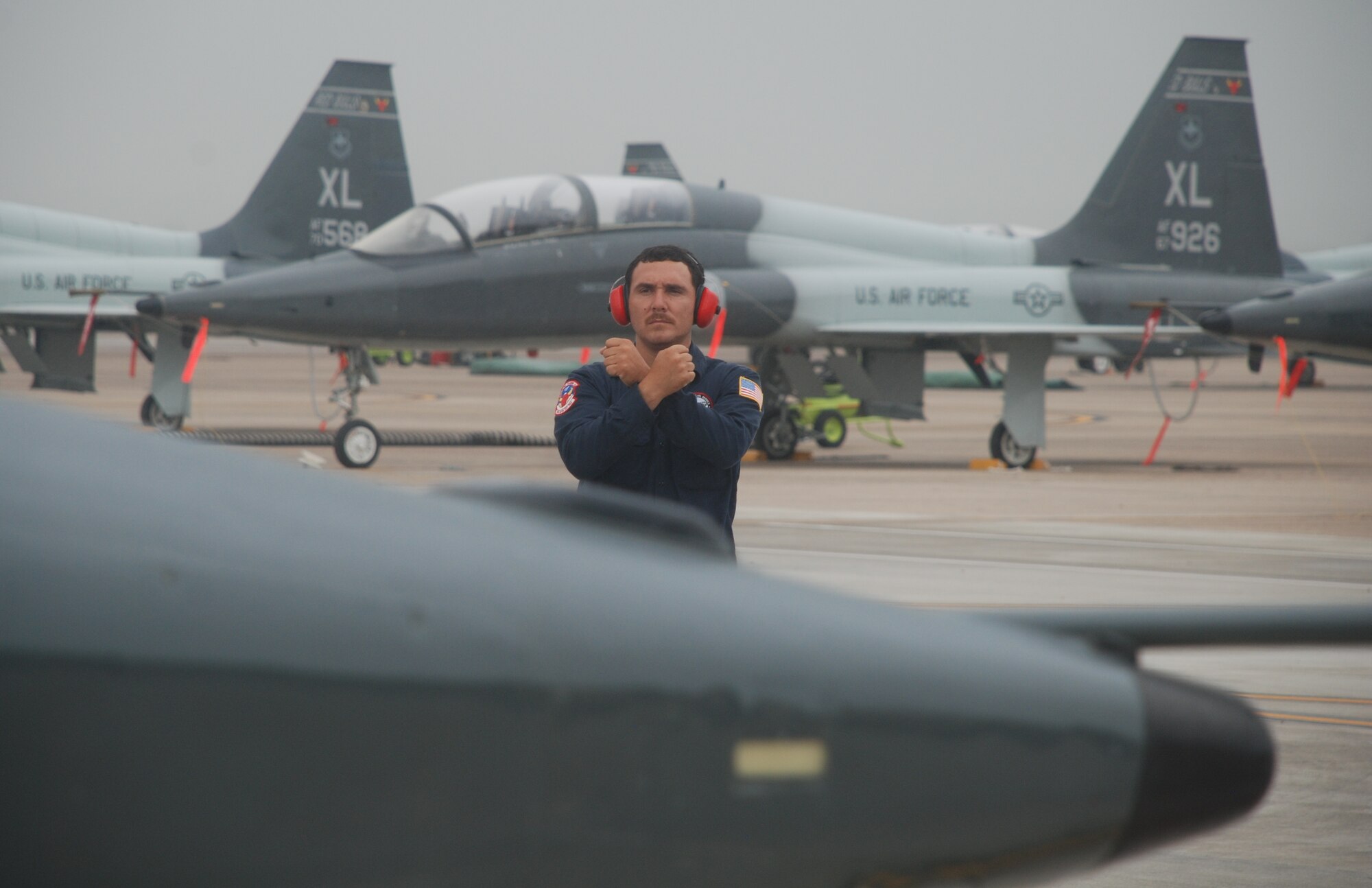 LAUGHLIN AIR FORCE BASE, Texas – Luis Ponce, 47th Maintenance Directorate, prepares a jet piloted by Col. Jeffrey McDaniels, 47th Flying Training Wing commander, for launch just before Colonel McDaniels’ last flight as wing commander May 17. Upon landing, as is tradition for the outgoing commander, Colonel McDaniels taxied through an arch of water supplied by fire trucks from Laughlin’s fire department and was drenched with a fire hose by his wife after exiting the aircraft. (U.S. Air Force photo by Airman 1st Class Blake Mize)