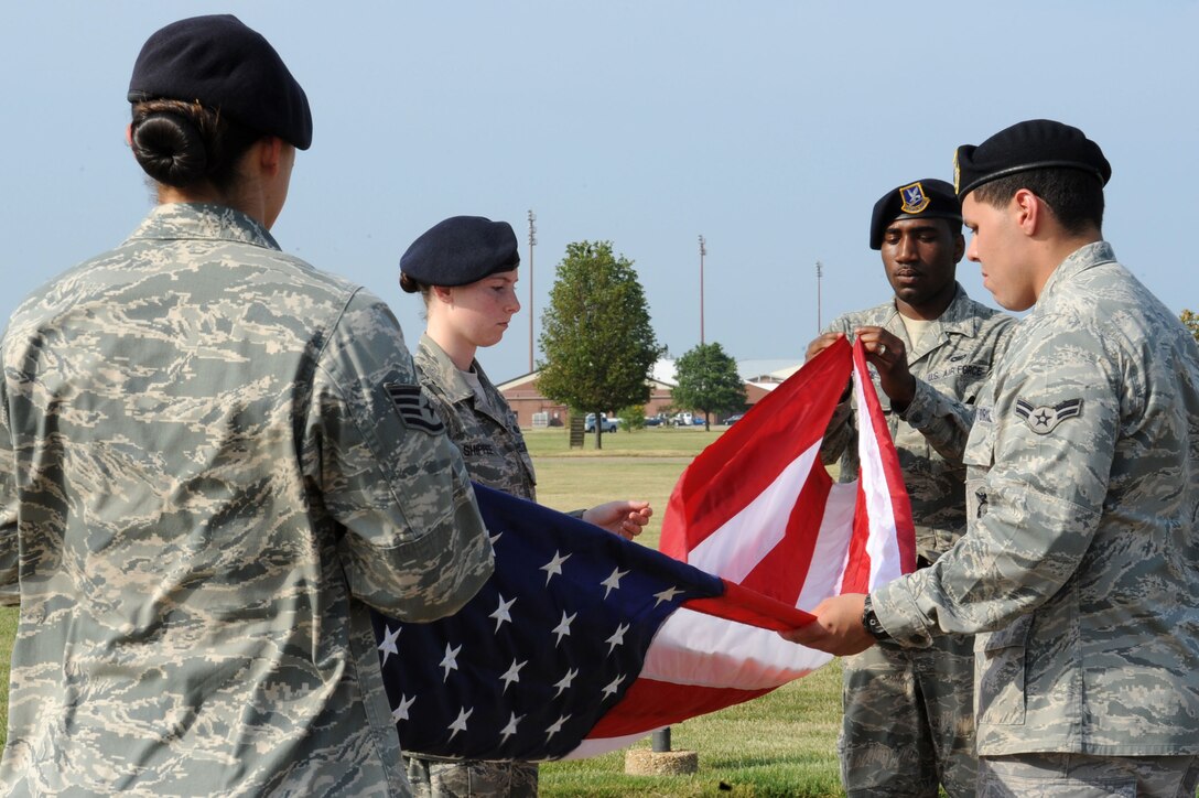 LANGLEY AIR FORCE BASE, Va. -- Staff Sgt. Evie Dougherty, Airman 1st Class Jonathon Andujar, Senior Airman Antonio Grace, and Airman 1st Class Ashley Shippee, 633d Security Forces Squadron patrolmen, fold the flag during a formal retreat ceremony honoring National Police Week May 14. Police Week is held annually to honor police officers, military and civilian, who have lost their lives in the line of duty. (U.S. Air Force Photo/Staff Sgt. Christina M. Styer) 