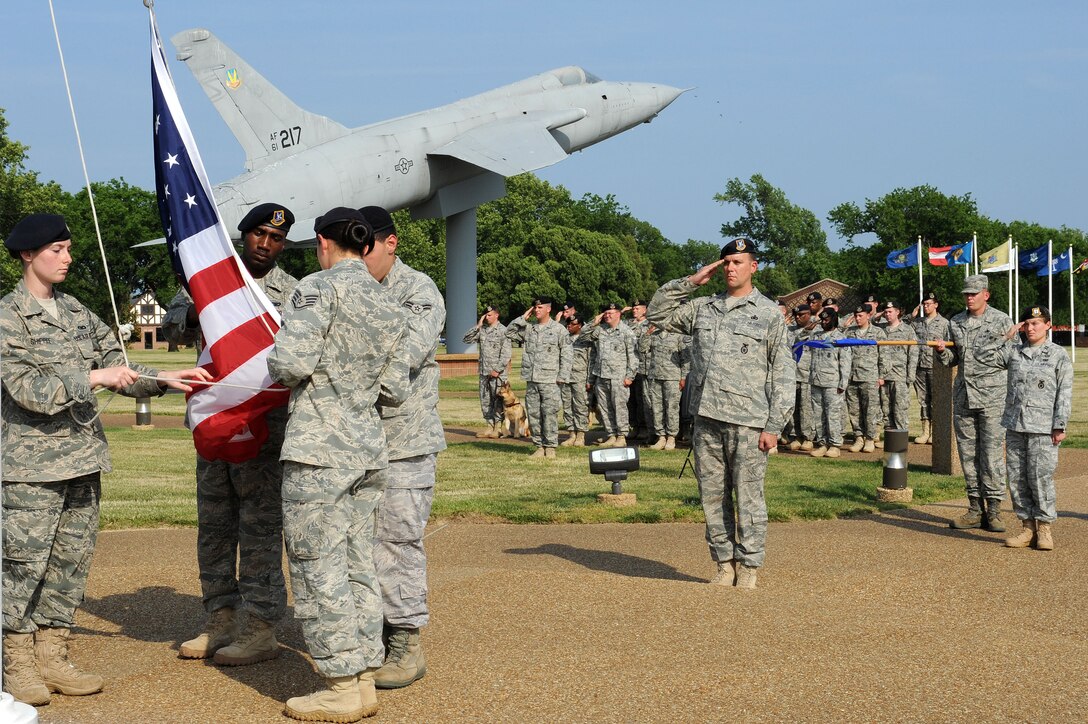 LANGLEY AIR FORCE BASE, Va. -- Staff Sgt. Evie Dougherty, Airman 1st Class Jonathon Andujar, Senior Airman Antonio Grace, and Airman 1st Class Ashley Shippee, 633d Security Forces Squadron patrolmen, gather the flag during a formal retreat ceremony honoring National Police Week May 14. Police Week is held annually to honor police officers, military and civilian, who have lost their lives in the line of duty. (U.S. Air Force Photo/Staff Sgt. Christina M. Styer) 