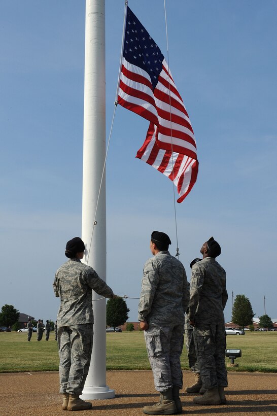 LANGLEY AIR FORCE BASE, Va. -- Staff Sgt. Evie Dougherty, Airman 1st Class Jonathon Andujar and Senior Airman Antonio Grace, 633d Security Forces Squadron patrolmen, lower the flag during a formal retreat ceremony honoring National Police Week May 14. Police Week is held annually to honor police officers, military and civilian, who have lost their lives in the line of duty. (U.S. Air Force Photo/Staff Sgt. Christina M. Styer) 