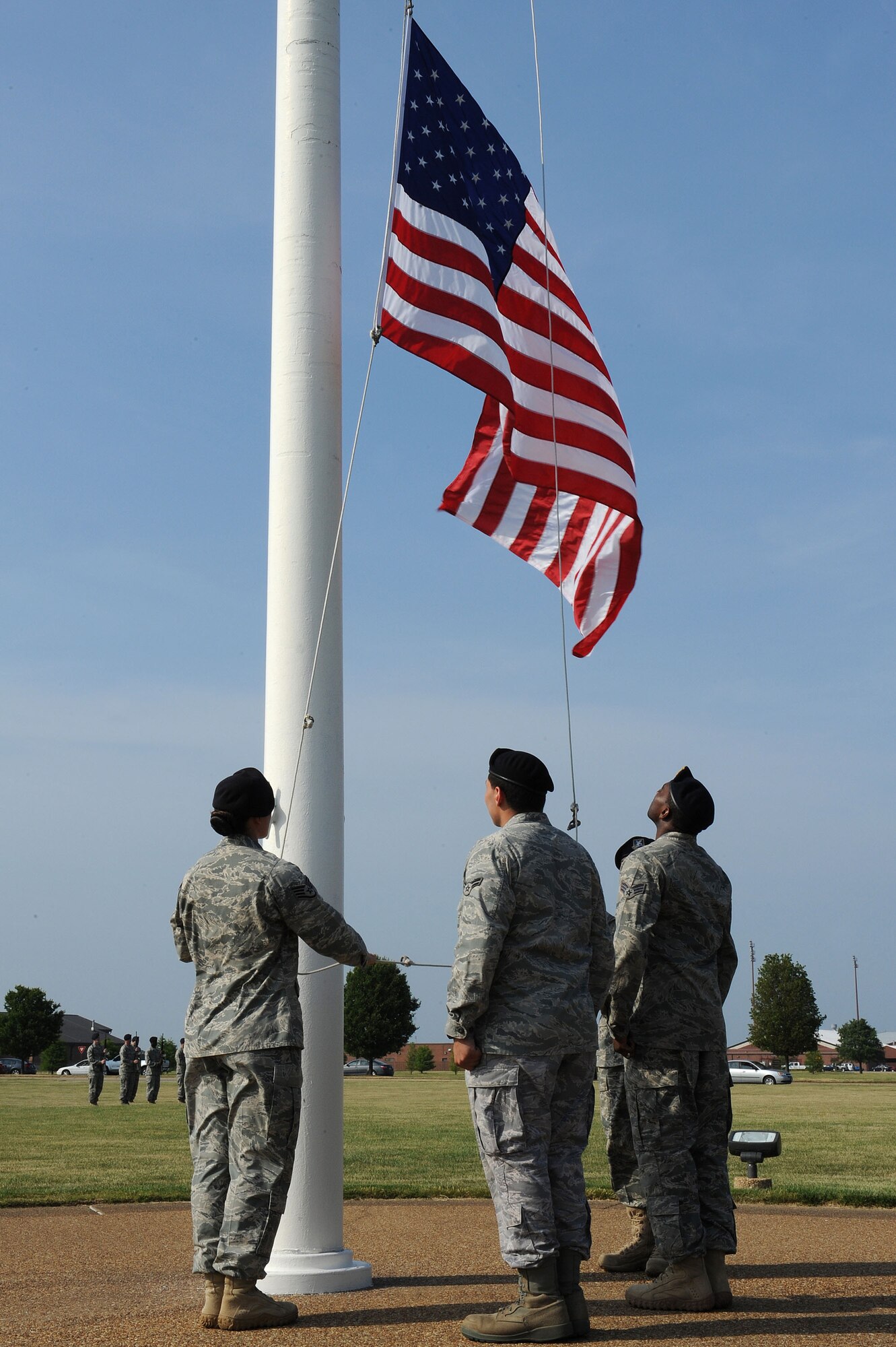 LANGLEY AIR FORCE BASE, Va. -- Staff Sgt. Evie Dougherty, Airman 1st Class Jonathon Andujar and Senior Airman Antonio Grace, 633d Security Forces Squadron patrolmen, lower the flag during a formal retreat ceremony honoring National Police Week May 14. Police Week is held annually to honor police officers, military and civilian, who have lost their lives in the line of duty. (U.S. Air Force Photo/Staff Sgt. Christina M. Styer) 