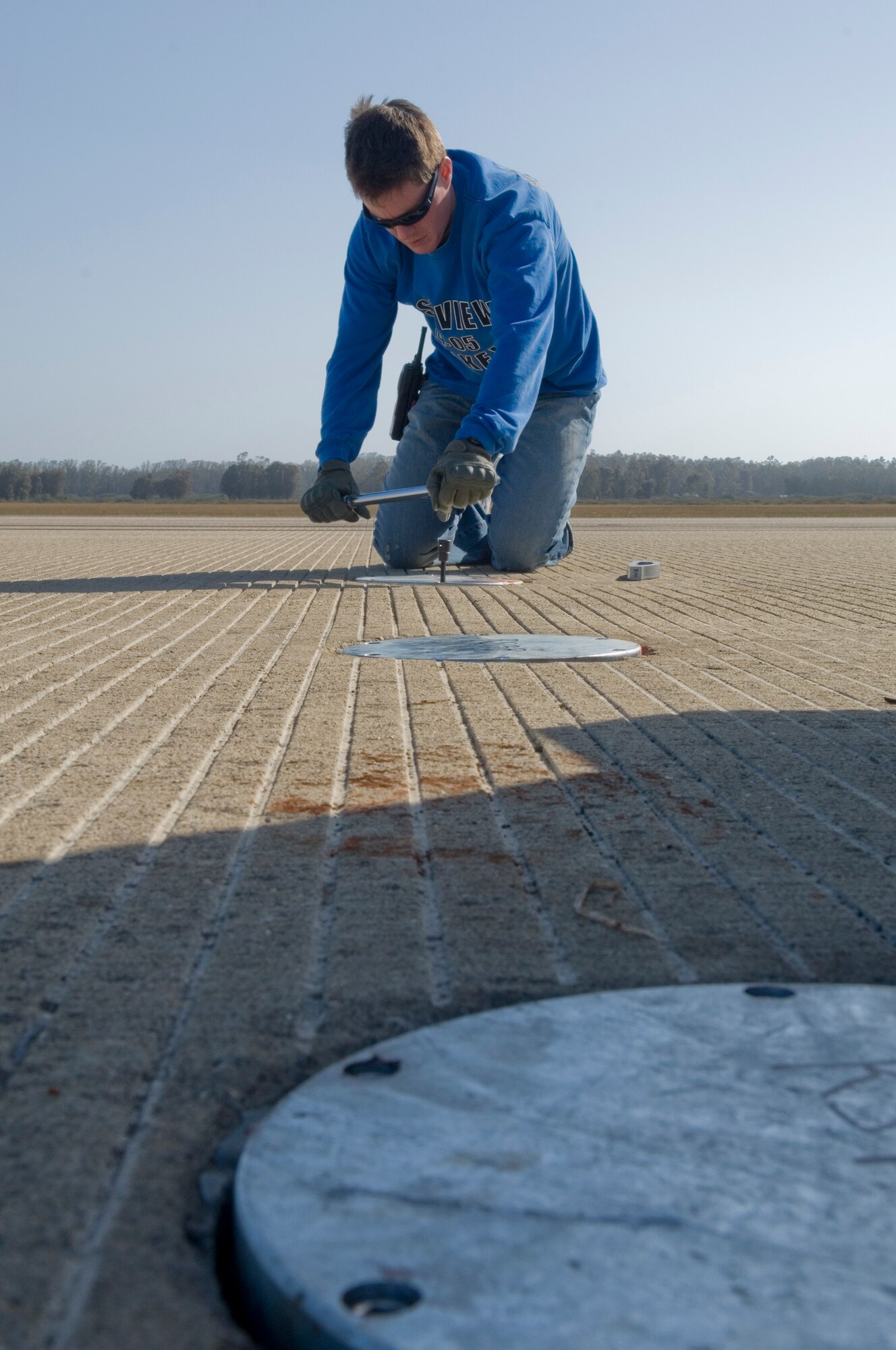 VANDENBERG AIR FORCE BASE, Calif. -- 2nd Lt. Mike Kelly, of the 30th Civil Engineer Squadron, tightens a bolt for a metal plate on the flightline at here Saturday, May 8, 2010. Construction crews replaced the metal plates to ensure the X-37B has a safe landing. (U.S. Air Force photo by Staff Sgt. Levi Riendeau)
