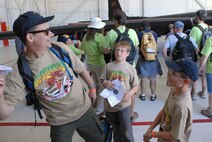 Major John Tate, a 13th Reconnaissance Squadron operations flight commander, demonstrates how to launch a paper airplane at mock-speed for his sons. The trio participated in the Boy Scout Expo held at Beale Air Force Base, Calif., April 30-May 2. (U.S. Air Force Photo/A1C Adam Hamar)