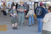 A scout and his father stroll through the make-shift museum of Boy Scout memorabilia. (U.S. Air Force Photo/A1C Adam Hamar)