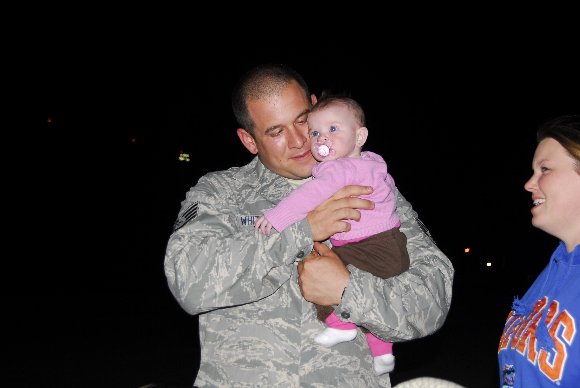 Staff Sgt. Stephen White, 43rd Security Forces Squadron, greets daughter Janel, 4 months, for the first time on Green Ramp. Sergeant White, along with 13 other SFS members, returned May 12 from a six month deployment to Afghanistan.