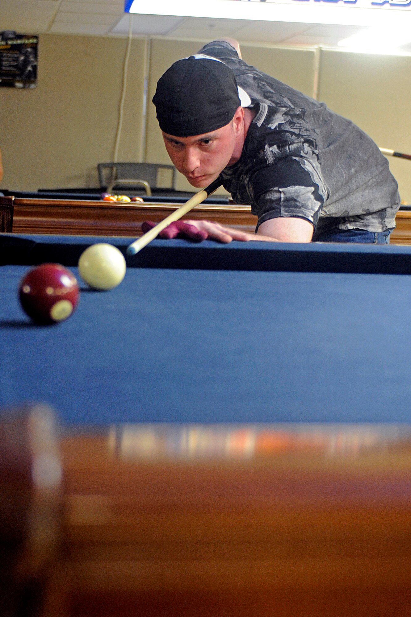 Airman 1st Class Sean Hatcher, 28th Aircraft Maintenance Squadron weapons load crew team member, lines up a shot during a nine-ball pool tournament at the Black Hills Center, May 15. Airman Hatcher finished second place out of eight participants. (U.S. Air Force photo/Airman 1st Class Matthew Flynn)