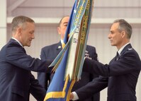 Command Chief Master Sgt. Agustin Huerta, center, watches as Maj. Gen. Eric Crabtree, left, Fourth Air Force commander, passes the flag of command to the newly assigned 452nd Air Mobility Wing commander, Col. Karl McGregor during the change of command ceremony inside the C-17 hangar at March Air Reserve Base, March 27. (U.S. Air Force photo by Staff Sgt. Stephen Schester)