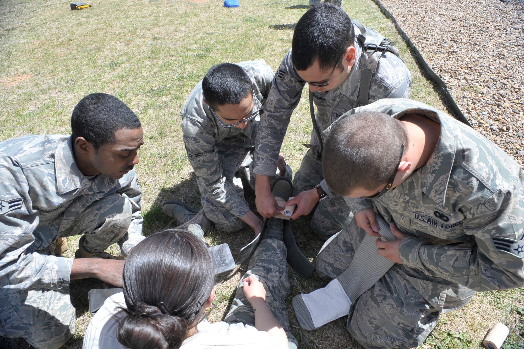 A team of Security Forces members  perform first aid on an actor during the  Defender Rally at Cannon AFB,10 May.  Events for the Defender Rally, part of National Police Week, included first aid, crime scene memorization, a written test, and a timed weapons knowledge event.   (U.S. Air Force photo by Staff Sgt. Heather R. Redman)
