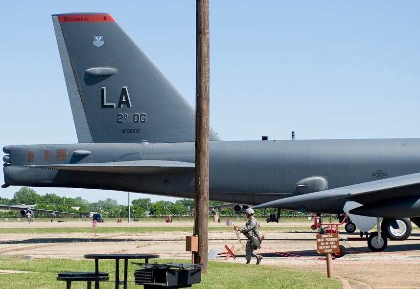BARKSDALE AIR FORCE BASE, La. – A patrolman from the 2d Security Forces Squadron pulls away the cordon around a B-52 Stratofortress during a Nuclear Operational Readiness Exercise May 8. The NORE was held to test the weapons-response capability of Barksdale Airmen. (U.S. Air Force photo / Senior Airman Chad Warren)