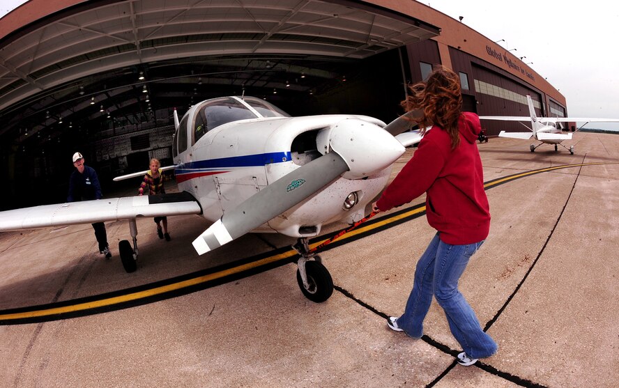 OFFUTT AIR FORCE BASE, Neb. -- Fifteen-year-old Jalie Bentz and 10-year-old Sydnie Voichoskie, walk an aircraft out of the LeMay Aero Club Hangar here May 15 prior to taking off on their one hour flight during Aviation Opportunities Day. Those who attended the event were given hands on training on how to prep an aircraft for preflight and instrument instructions. Attendees also were given aircraft tours and a one hour introductory flight with an instructor. U.S. Air Force Photo by Josh Plueger 